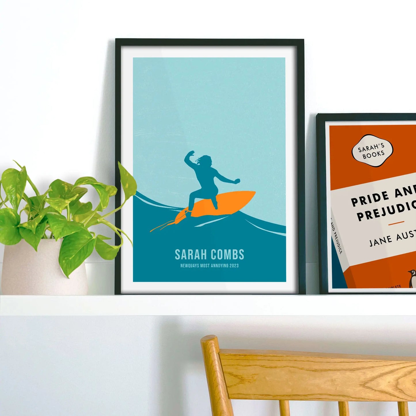 Framed picture on a baby blue wall beside pink shelving