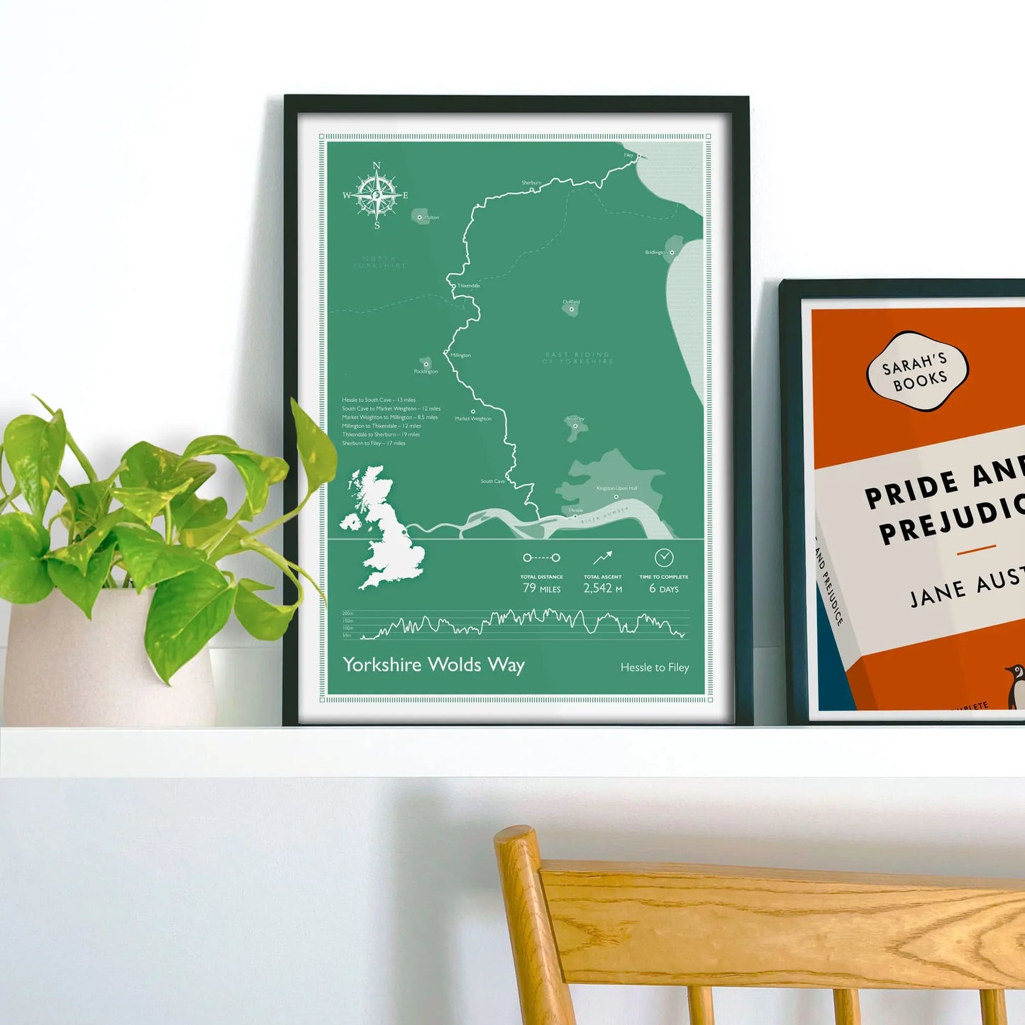 Framed art print on a green wall beside shelves.