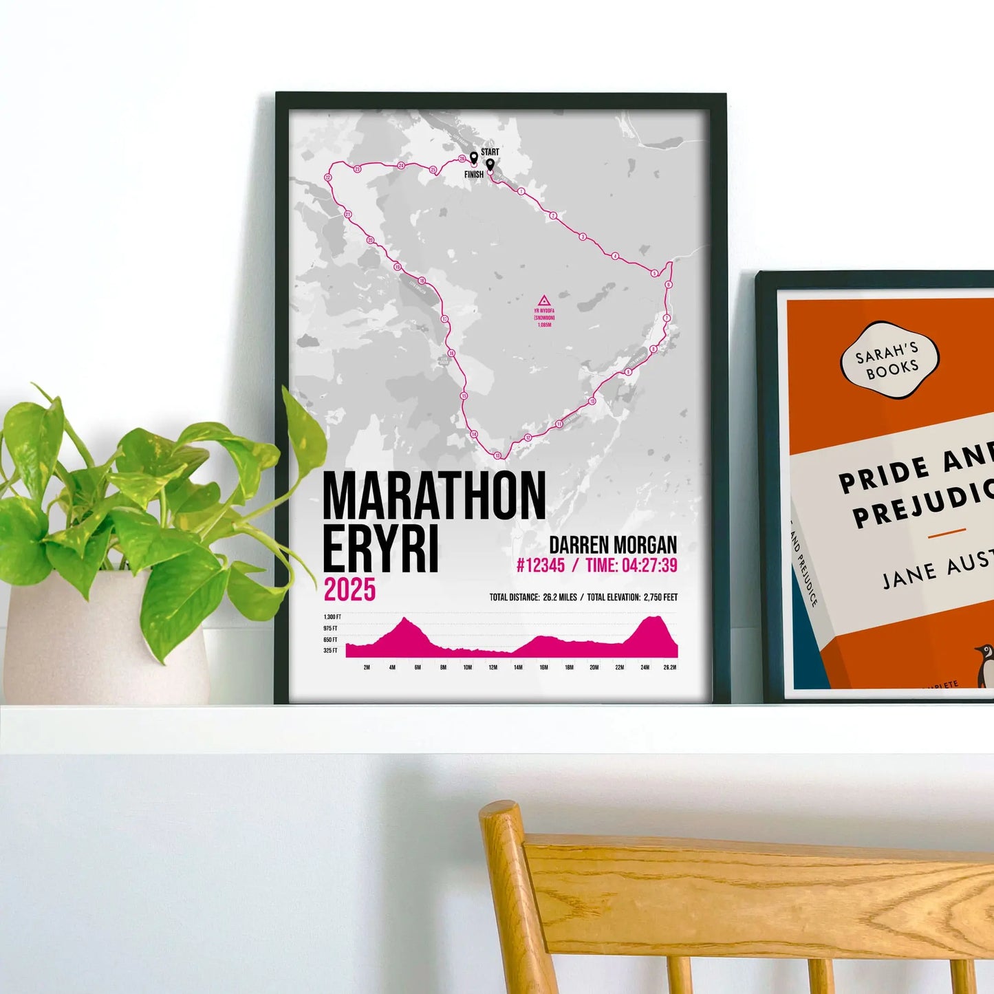 Framed print on shelf beside houseplant and another print