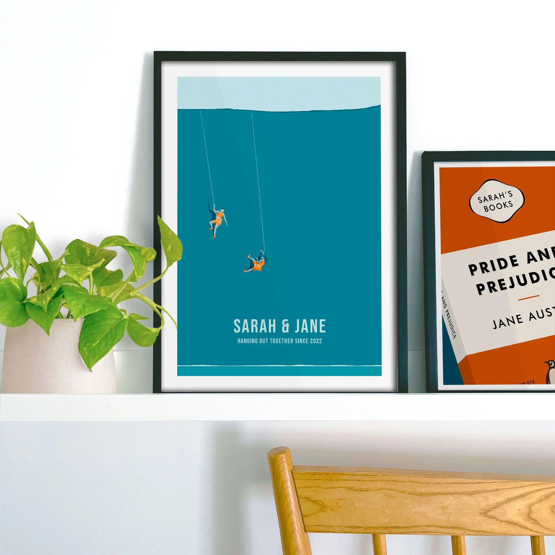 Framed print propped up on shelf beside a houseplant