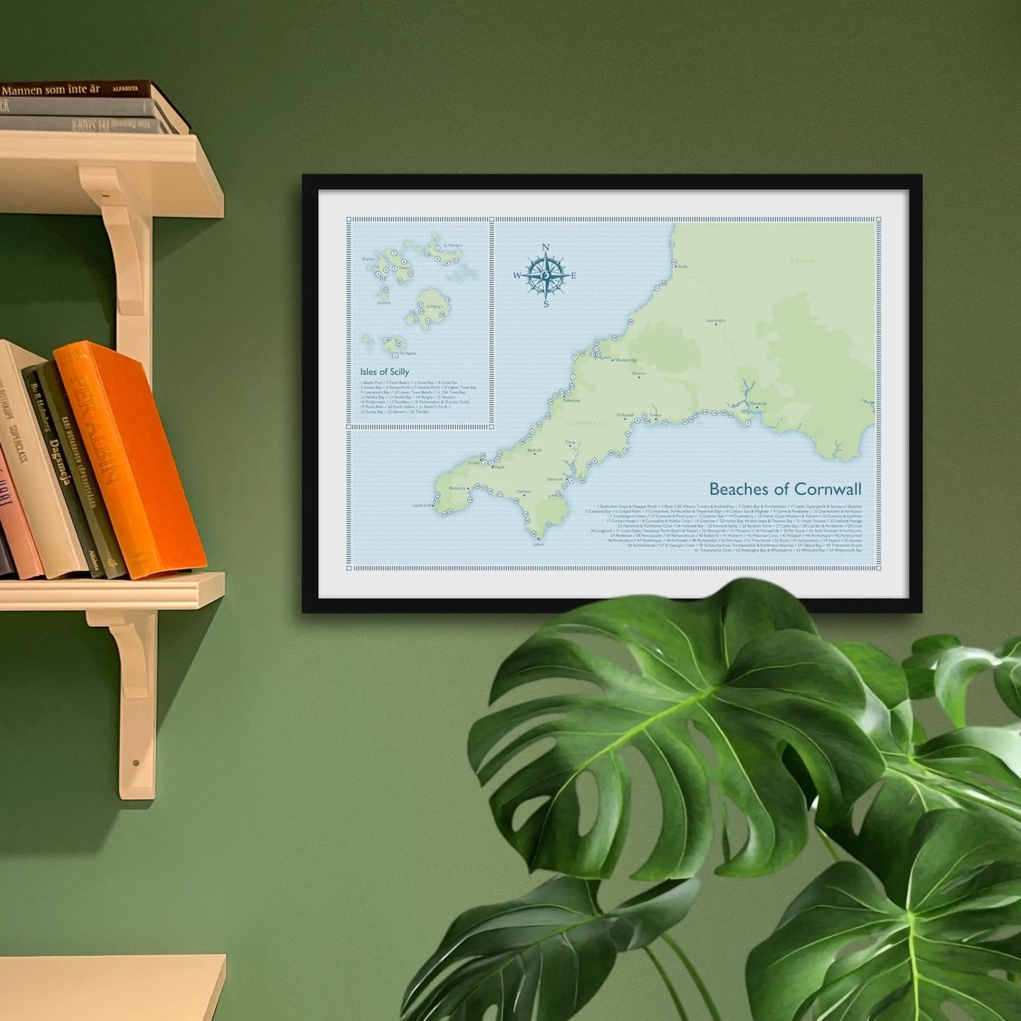 Framed art print on a green wall beside shelves.