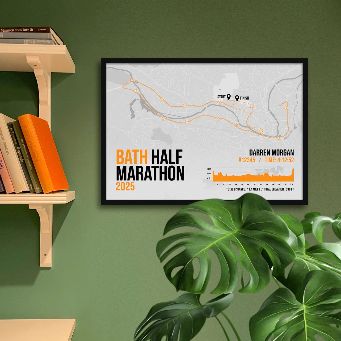 Print framed and in a black frame on a green wall beside some shelves