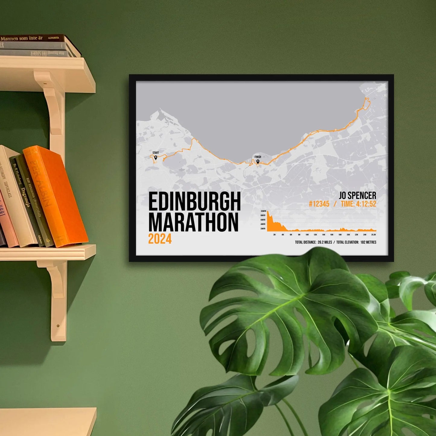 Framed art print on a green wall beside shelves.