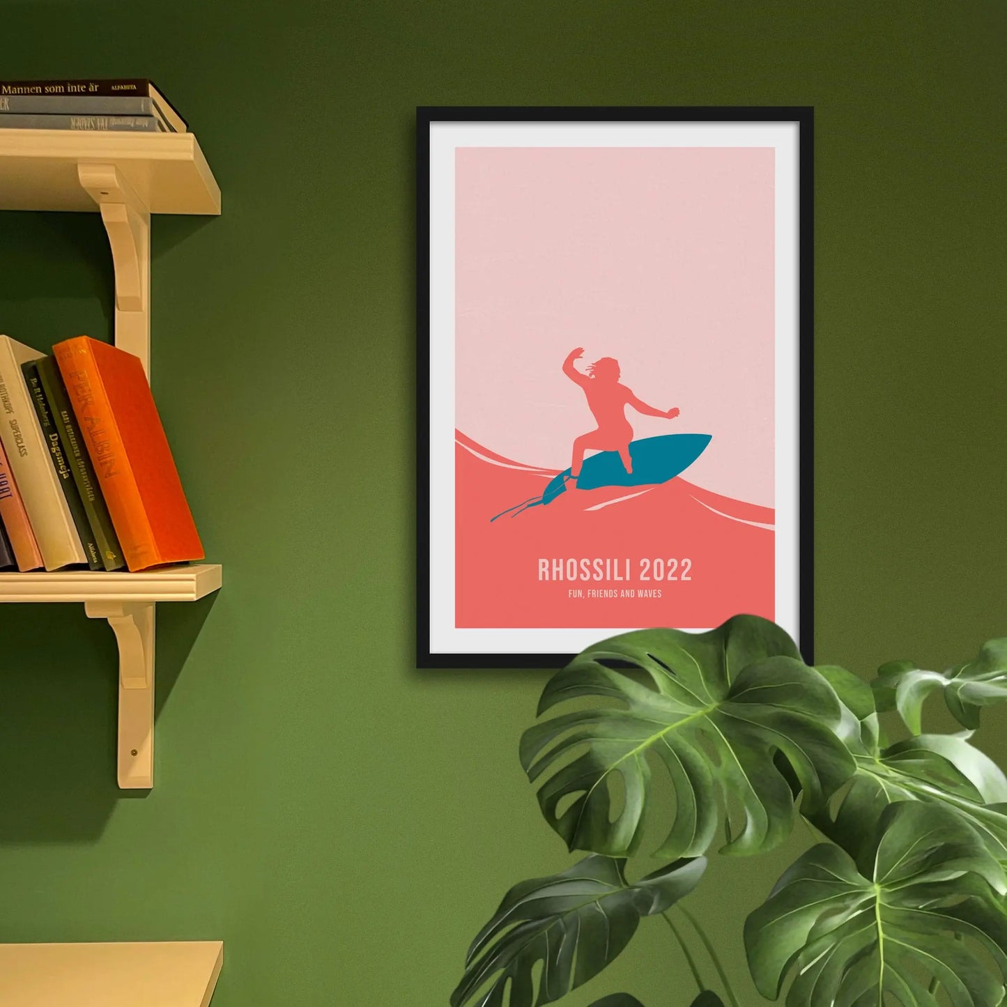 Framed art print on a green wall beside shelves.