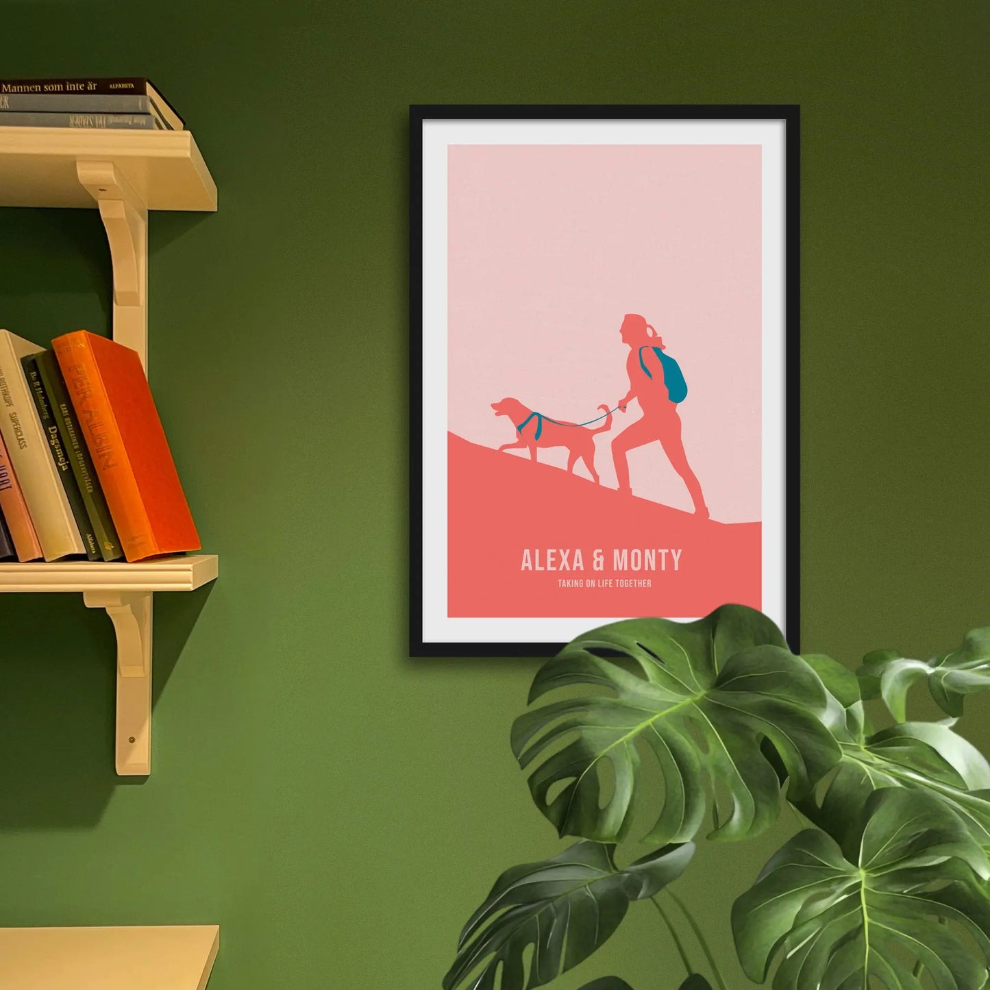 Framed print on green wall beside shelves behind houseplant.