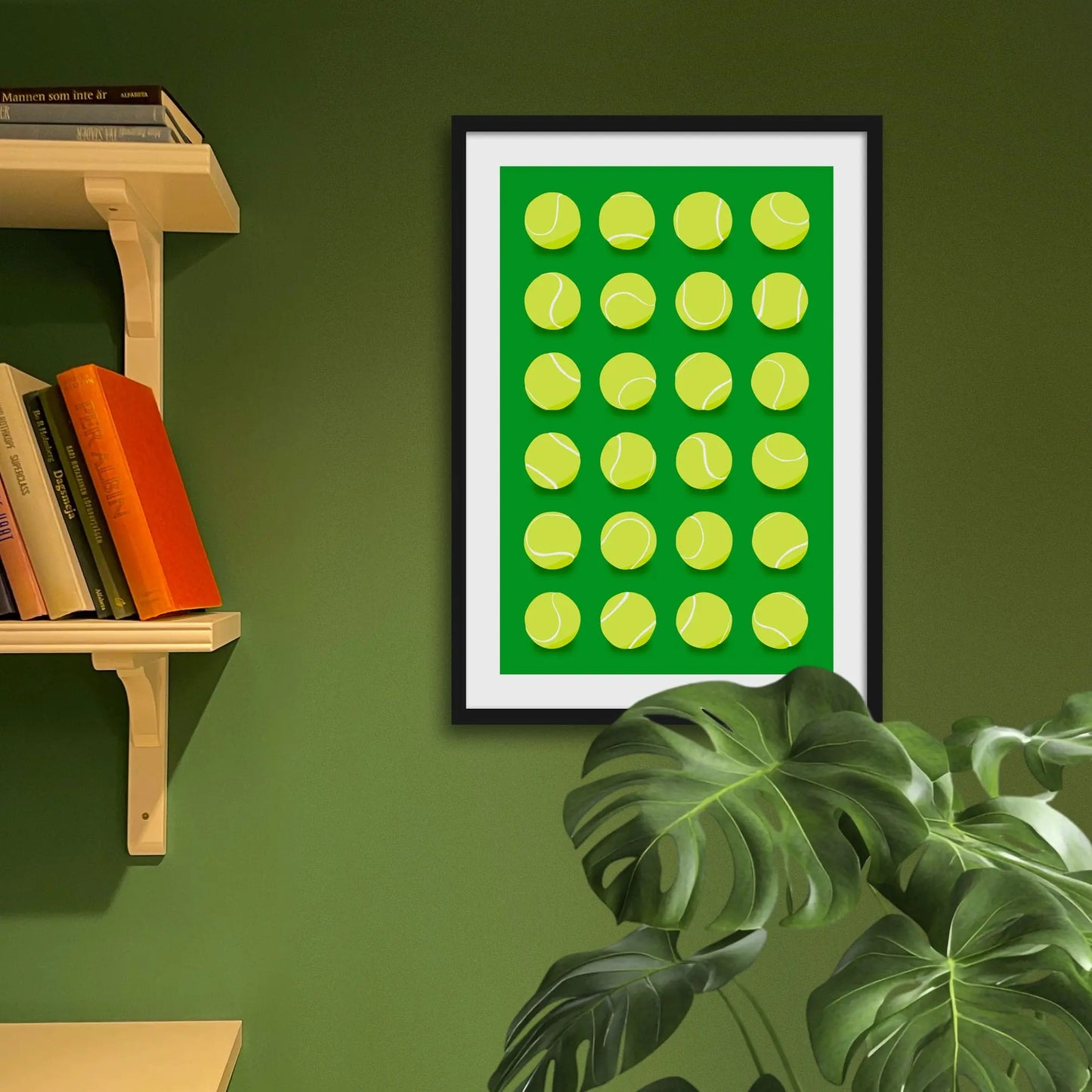 Framed art print on a green wall beside shelves.