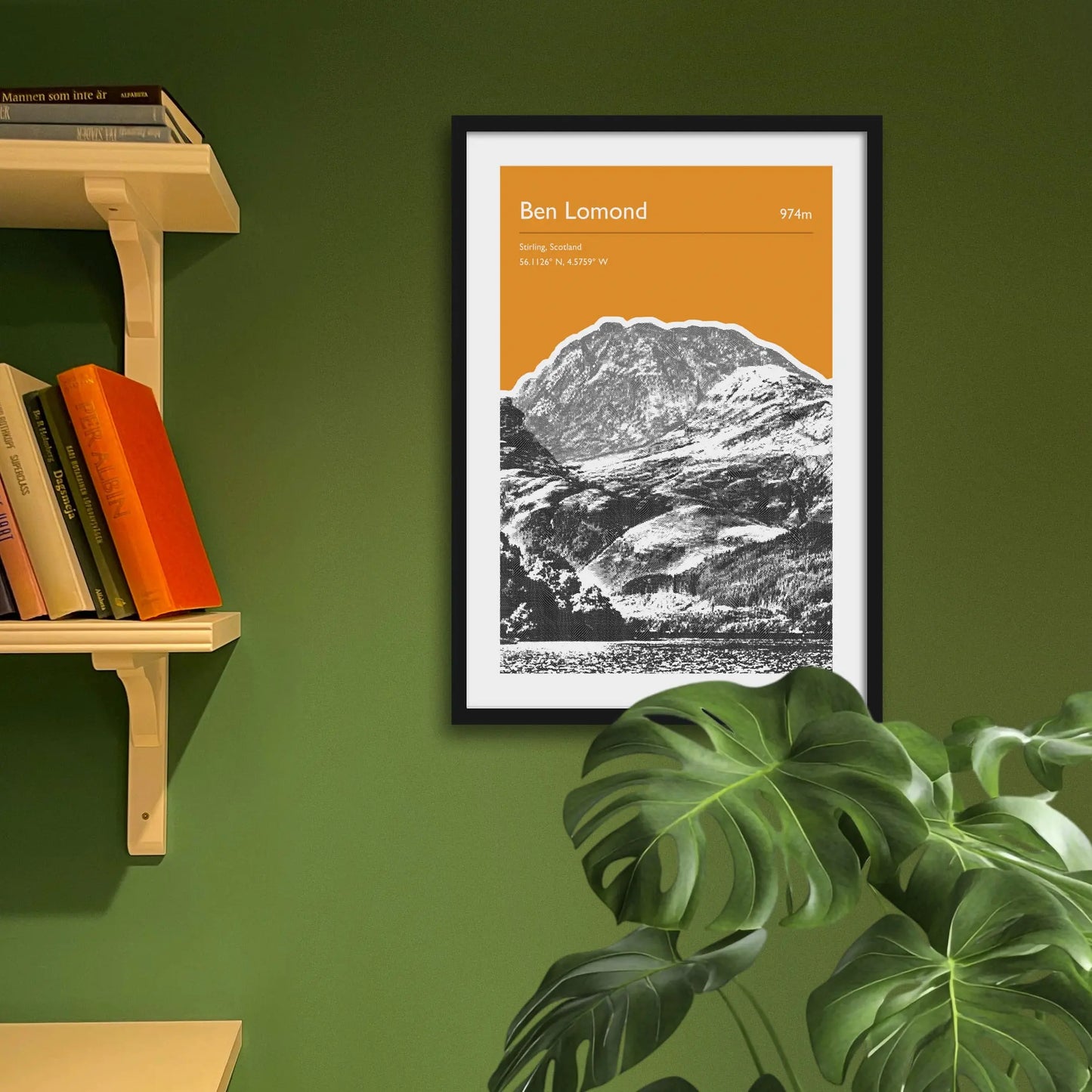 Framed art print on a green wall beside shelves.
