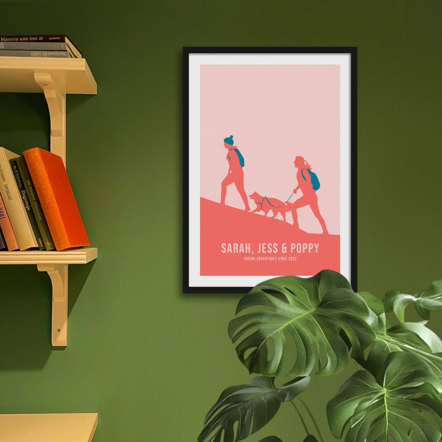 Framed print on green wall beside shelves behind houseplant.