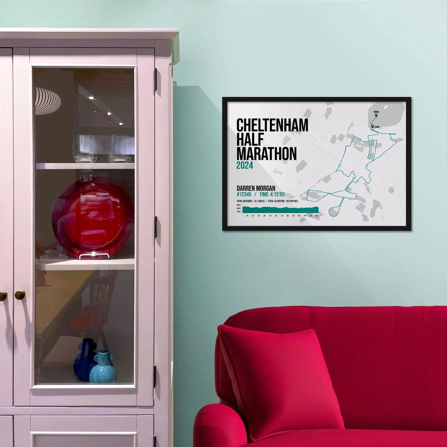 Framed picture on a baby blue wall beside pink shelving