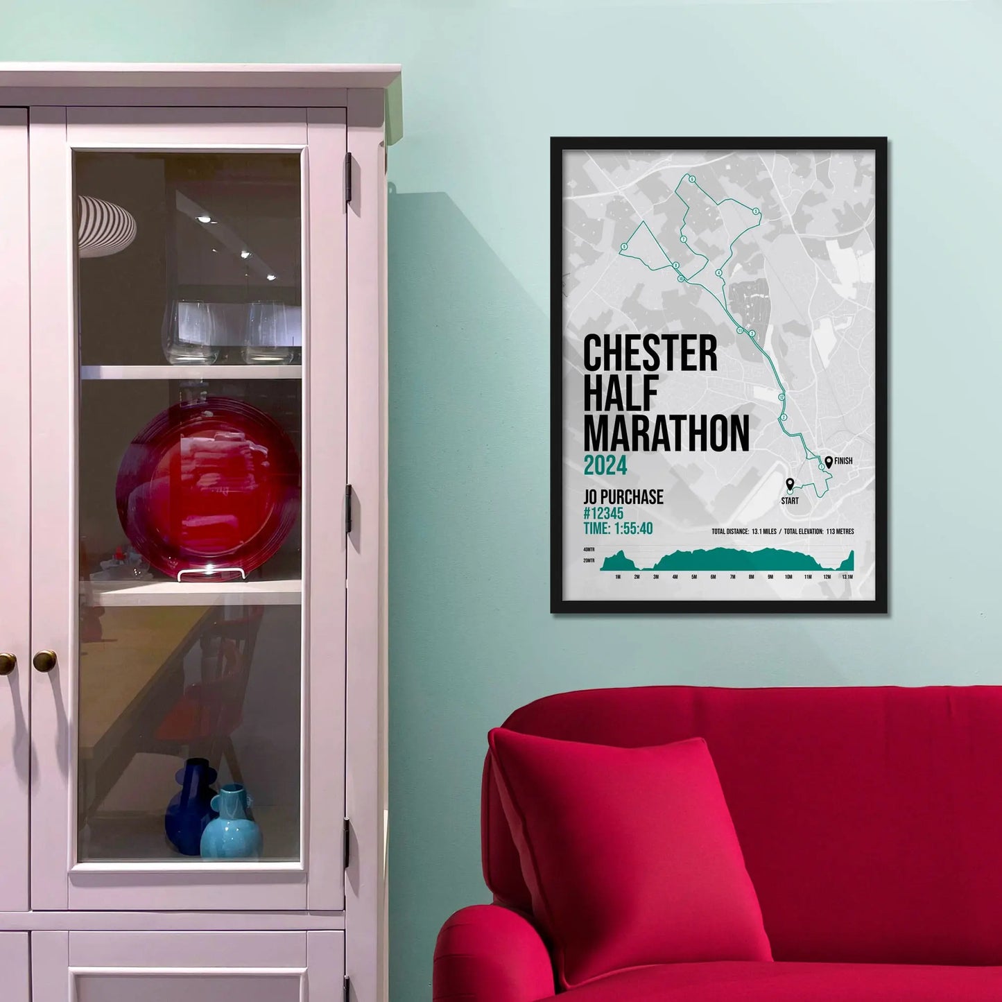Framed picture on a baby blue wall beside pink shelving