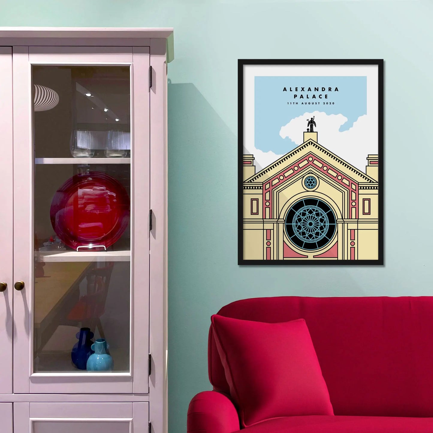 Framed picture on a baby blue wall beside pink shelving