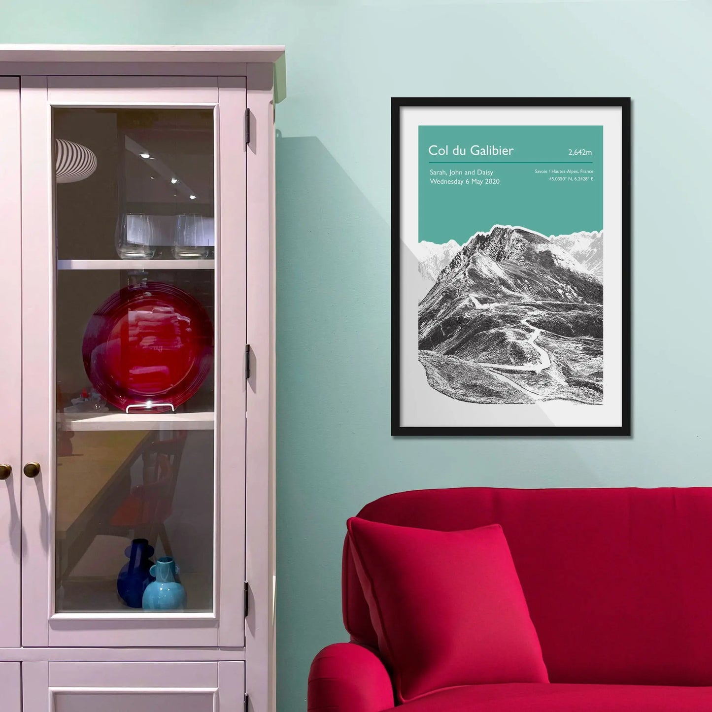 Framed picture on a baby blue wall beside pink shelving