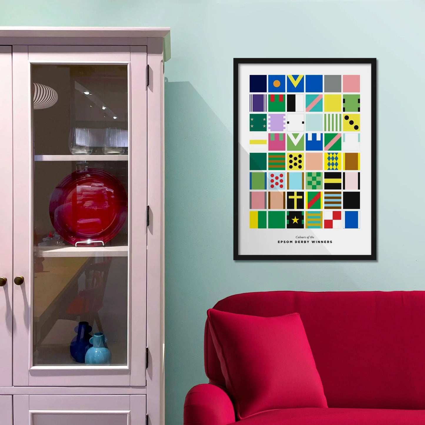 Framed picture on a baby blue wall beside pink shelving