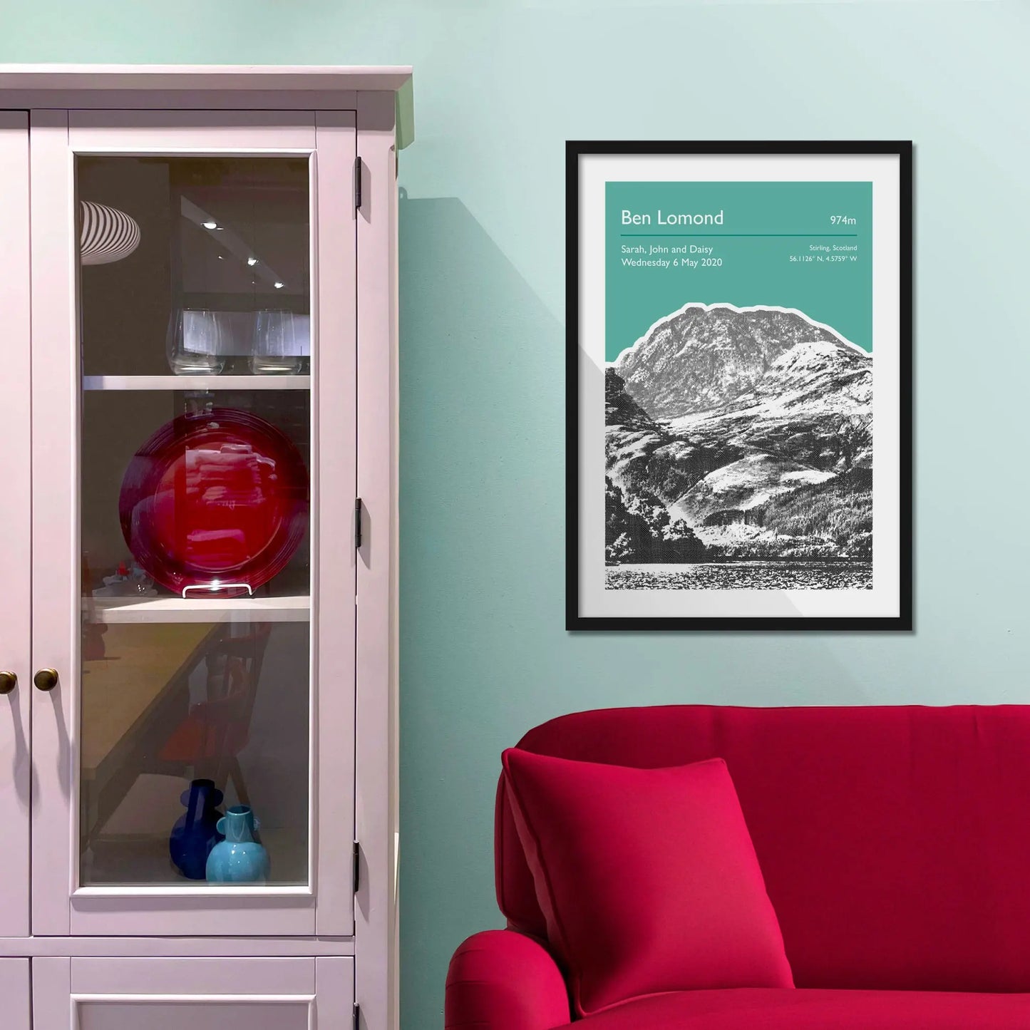 Framed picture on a baby blue wall beside pink shelving