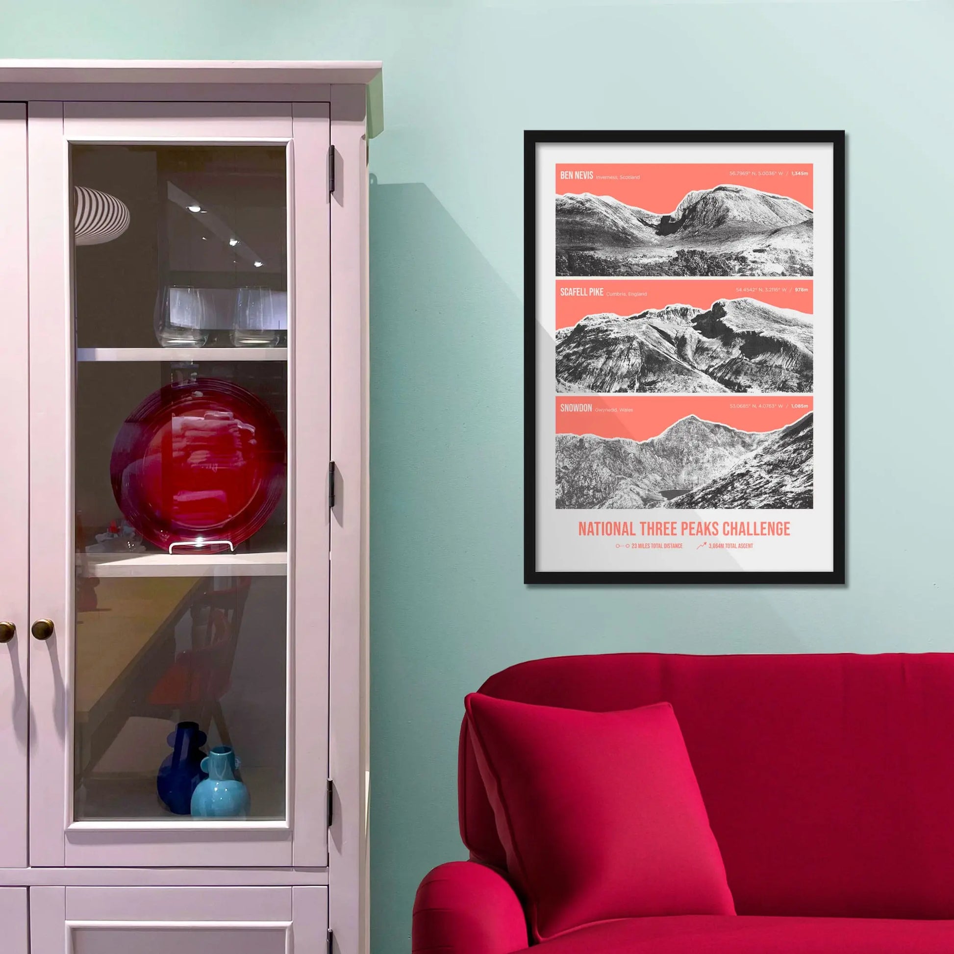 Framed print on baby blue wall beside pink shelves and behind a red sofa
