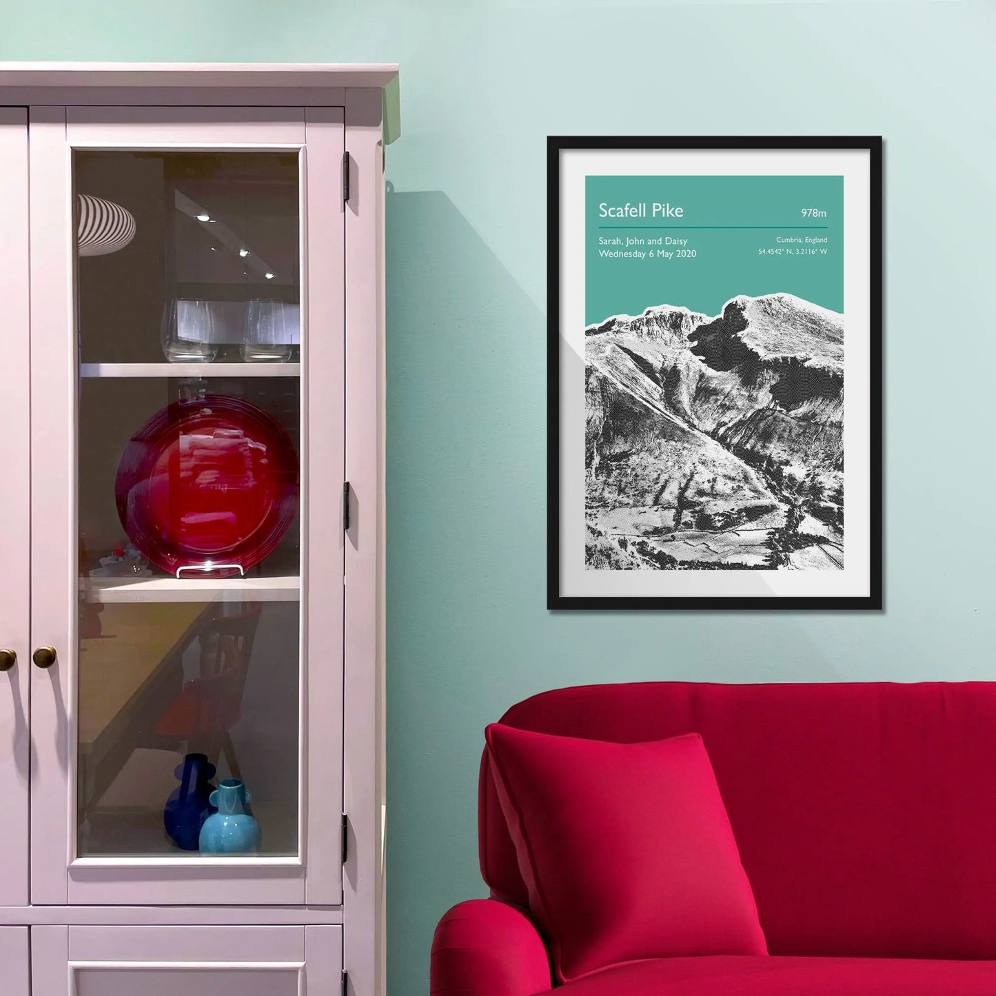 Framed picture on a baby blue wall beside pink shelving