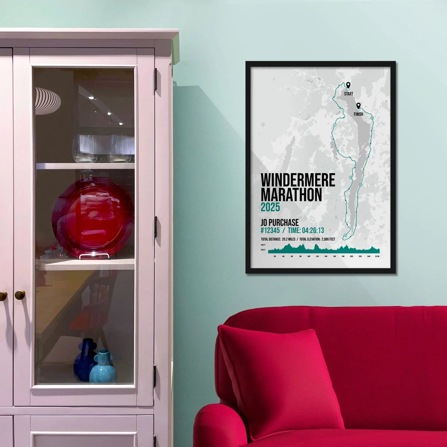 Framed picture on a baby blue wall beside pink shelving