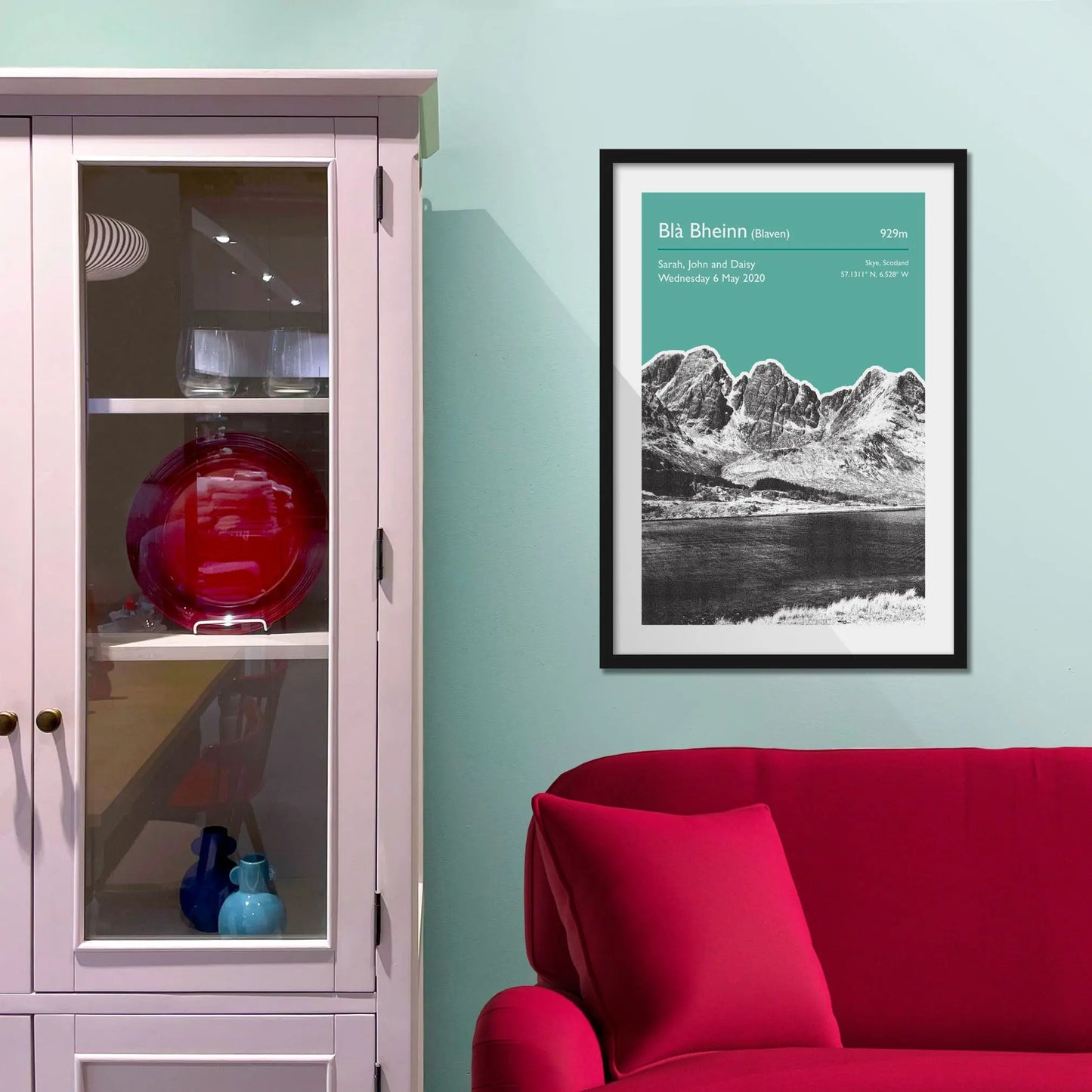 Framed picture on a baby blue wall beside pink shelving