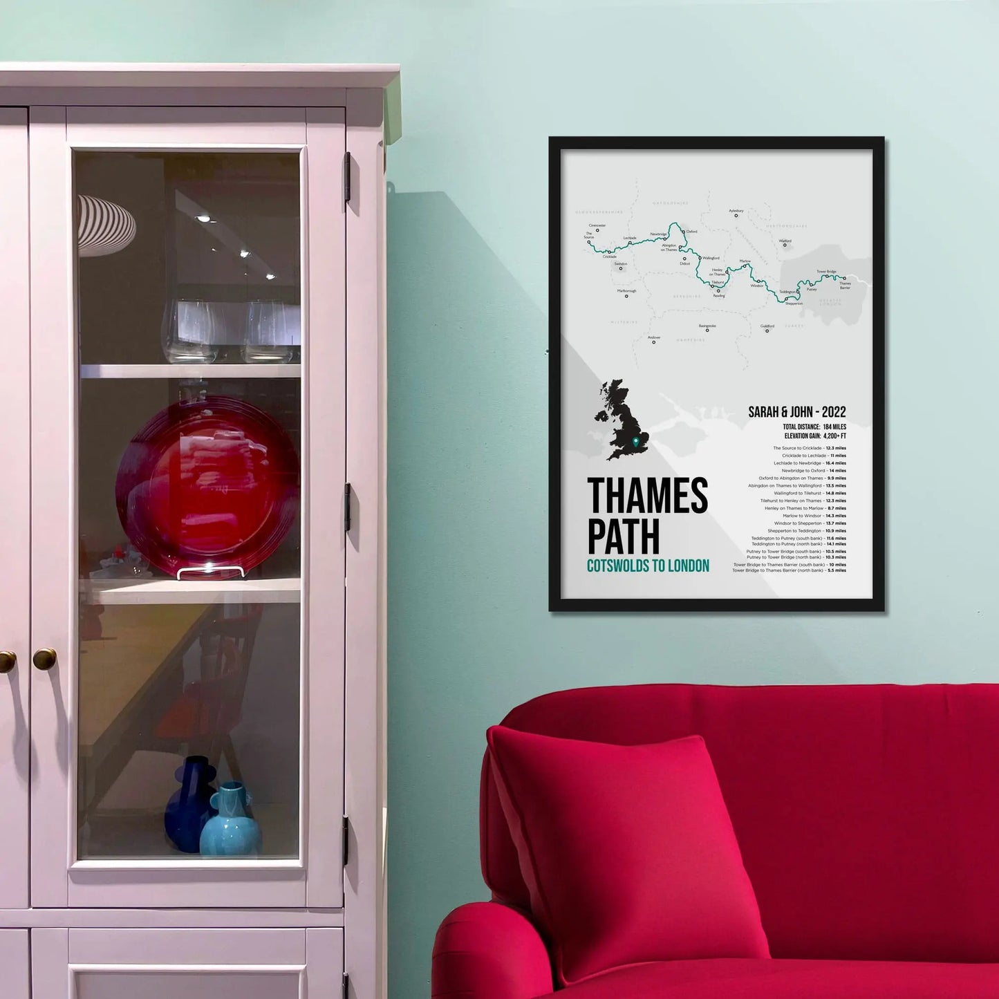 Framed print on light blue wall beside pink shelving unit.