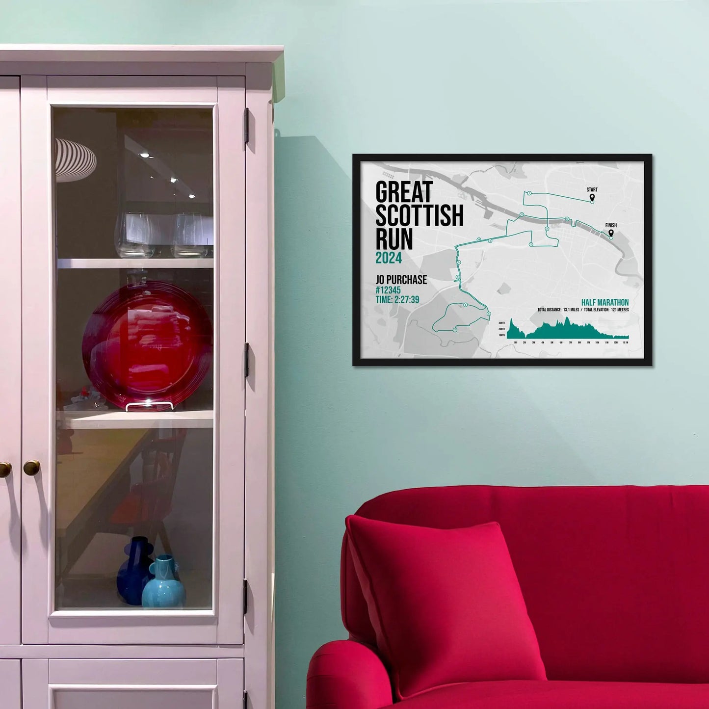 Framed picture on a baby blue wall beside pink shelving