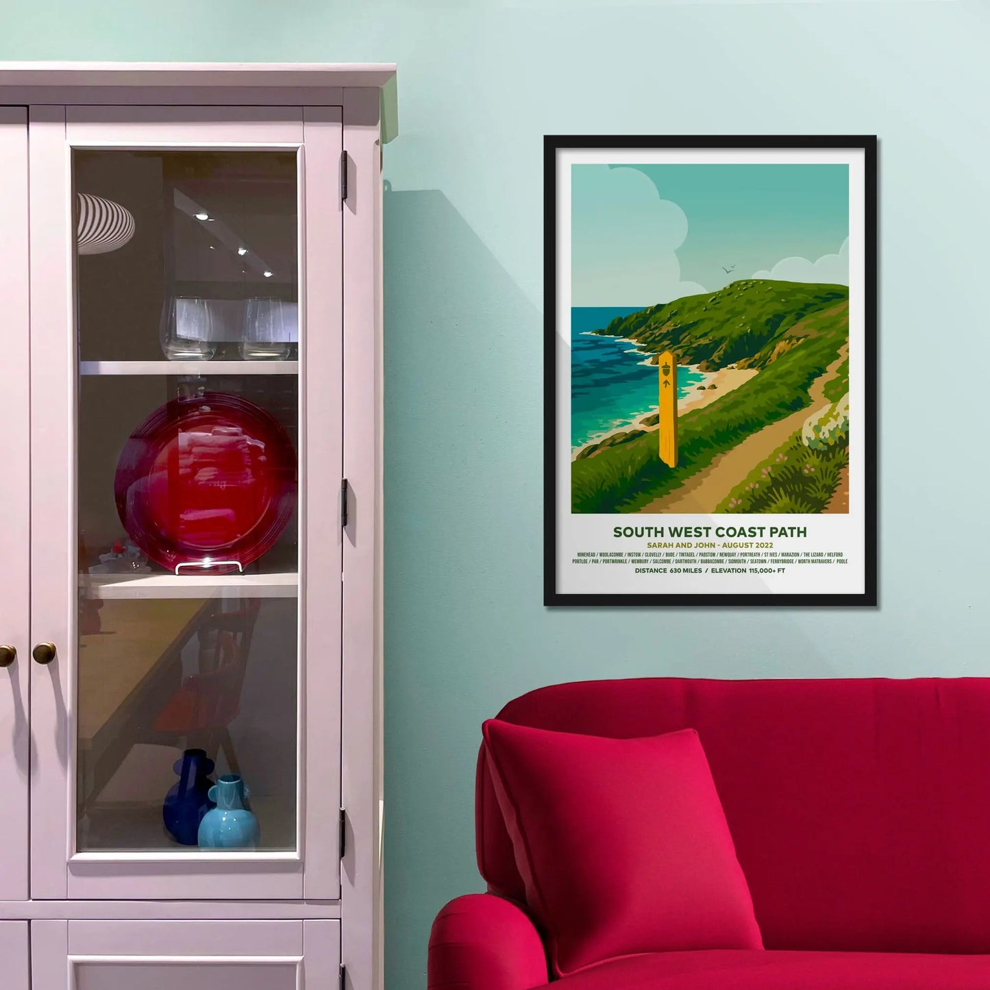 Framed picture on a baby blue wall beside pink shelving