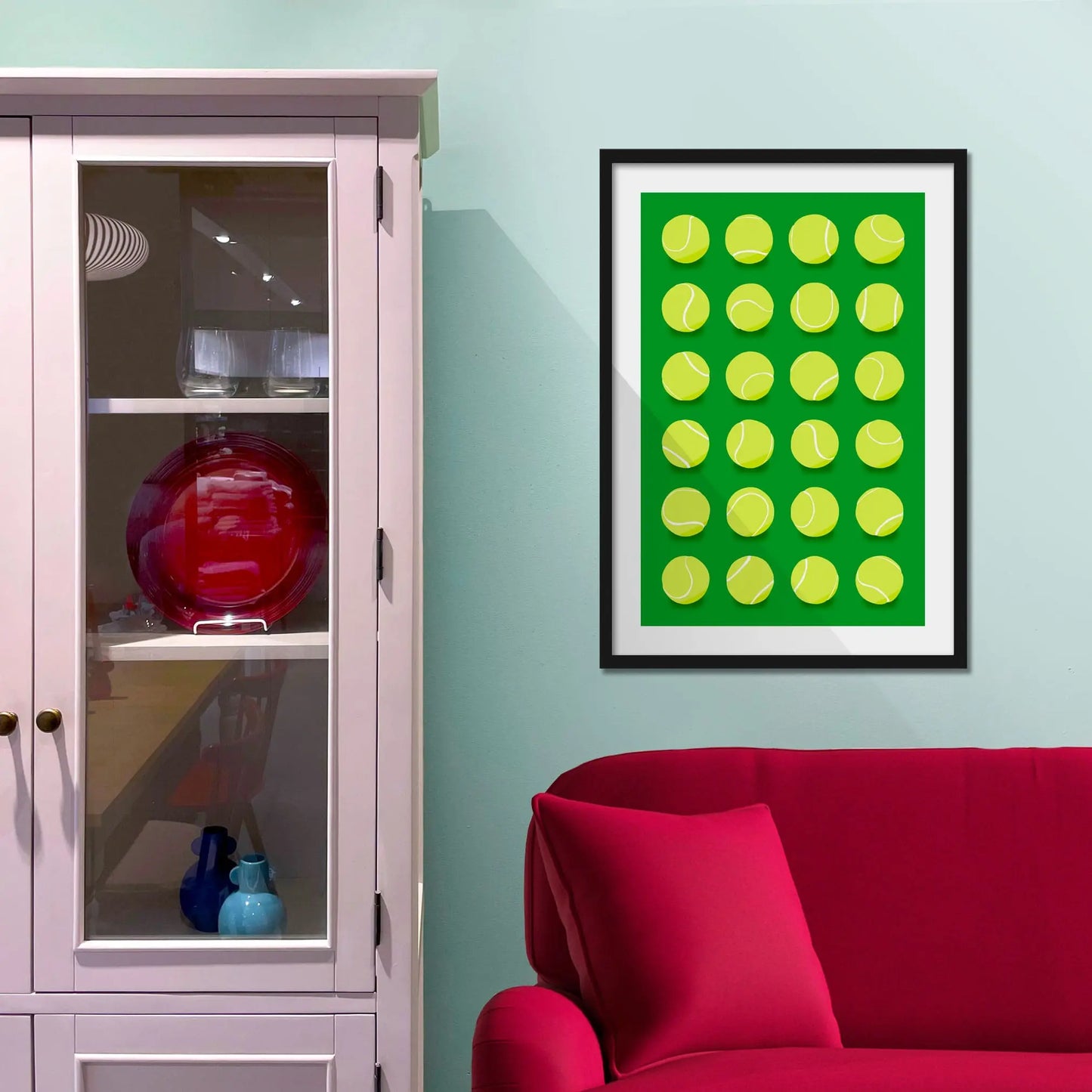 Framed picture on a baby blue wall beside pink shelving