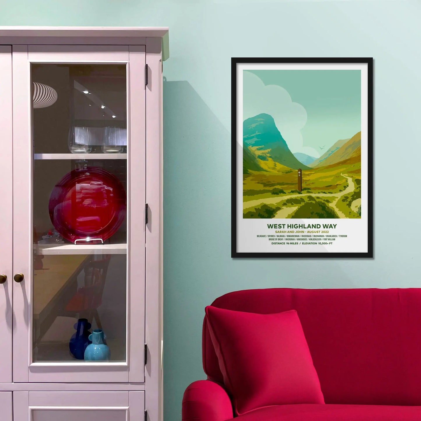 Framed picture on a baby blue wall beside pink shelving