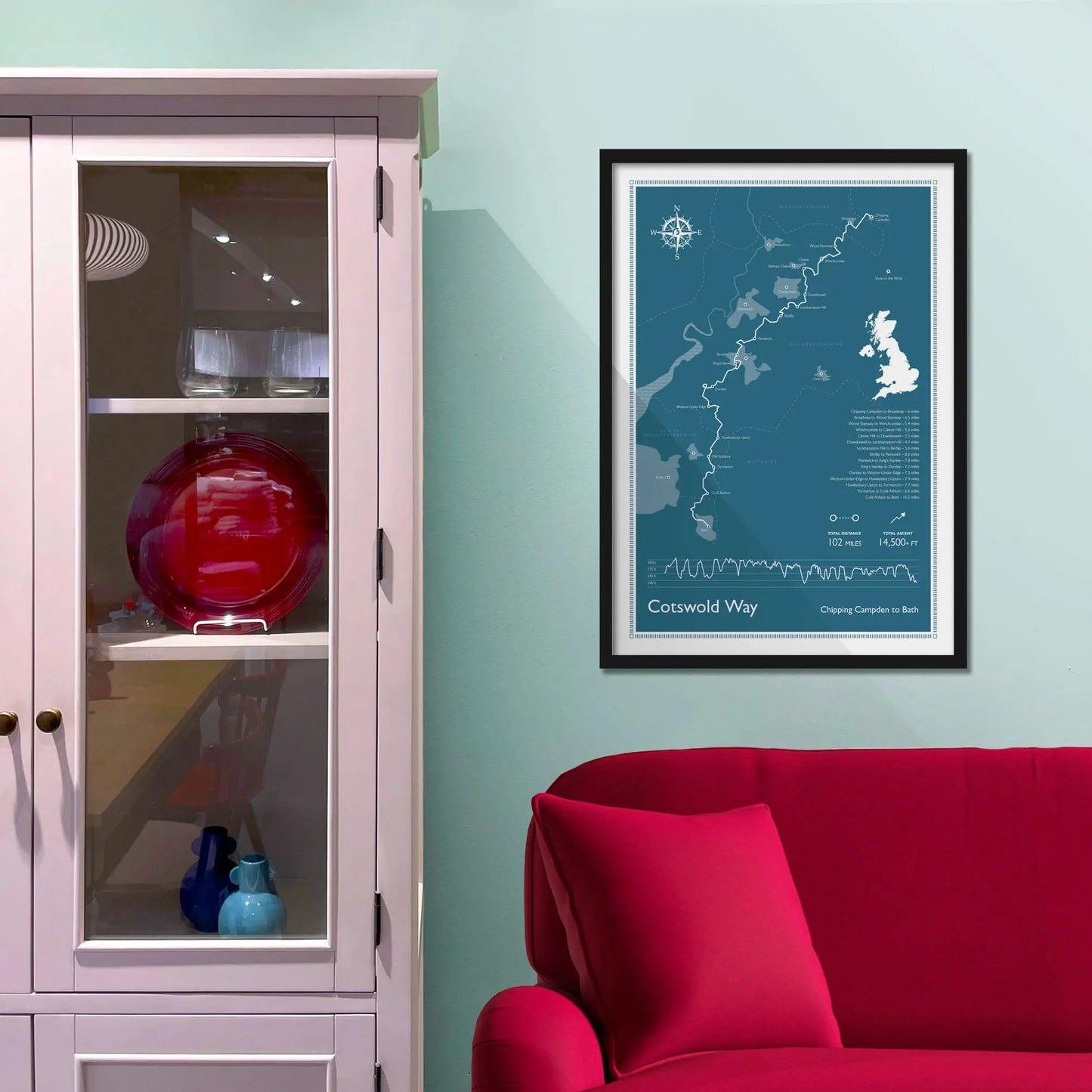 Framed picture on a baby blue wall beside pink shelving