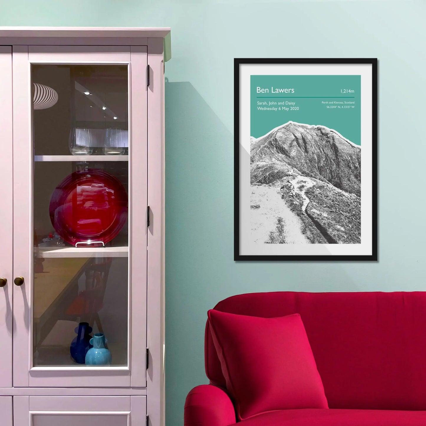 Framed picture on a baby blue wall beside pink shelving