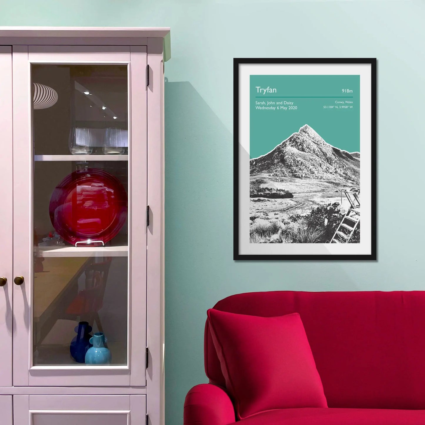 Framed picture on a baby blue wall beside pink shelving
