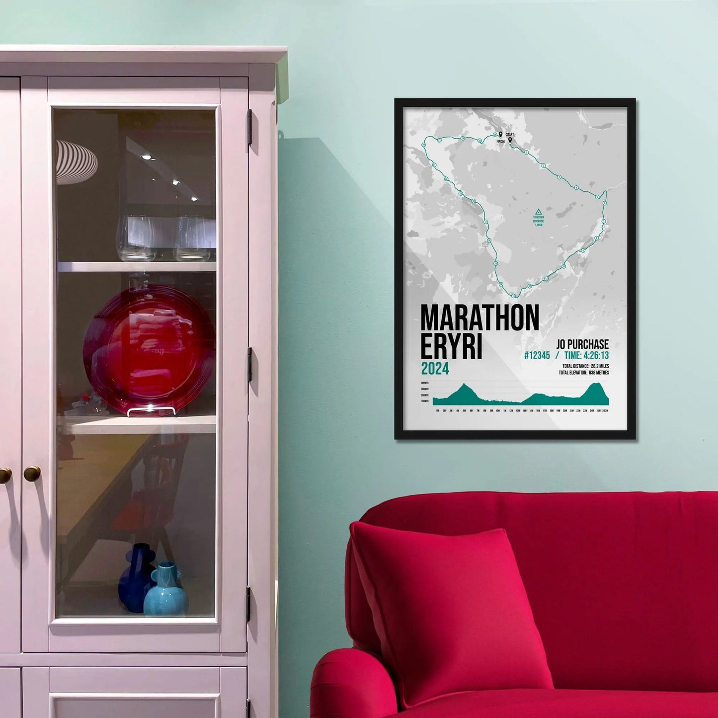 Framed picture on a baby blue wall beside pink shelving