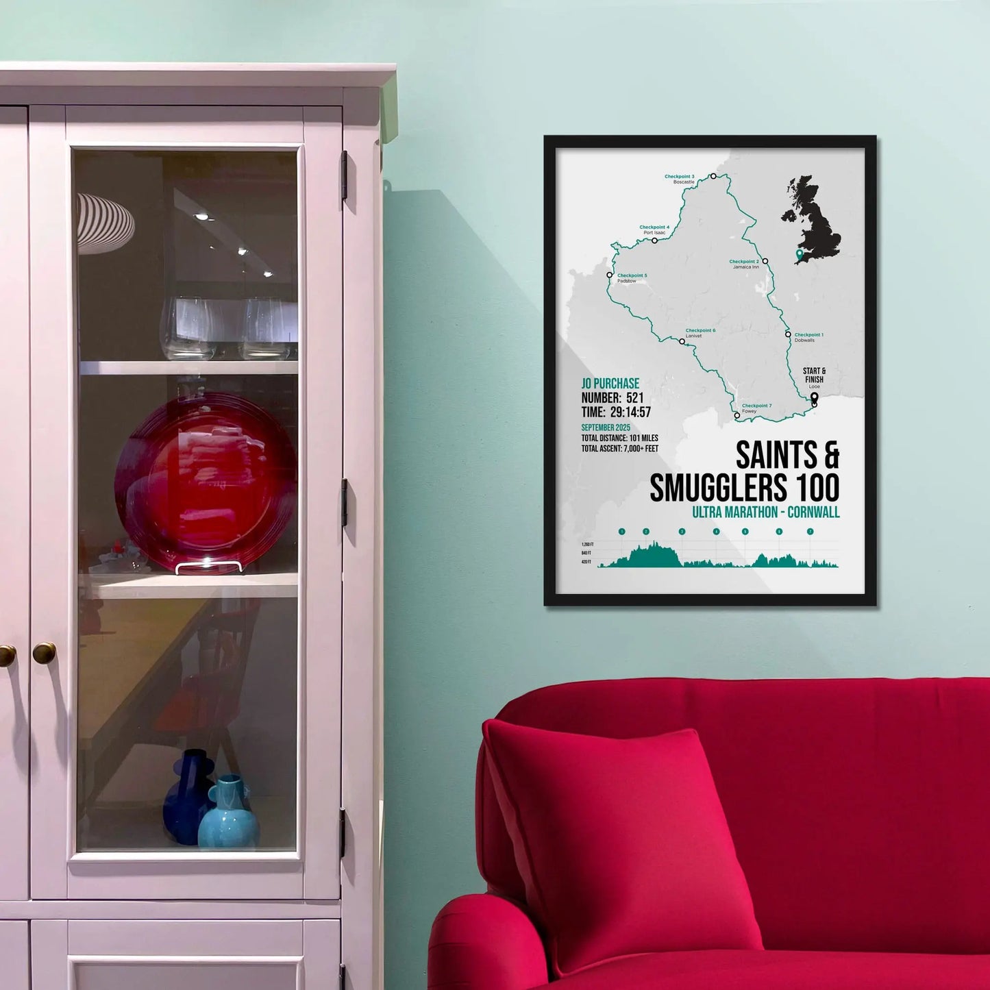 Framed picture on a baby blue wall beside pink shelving