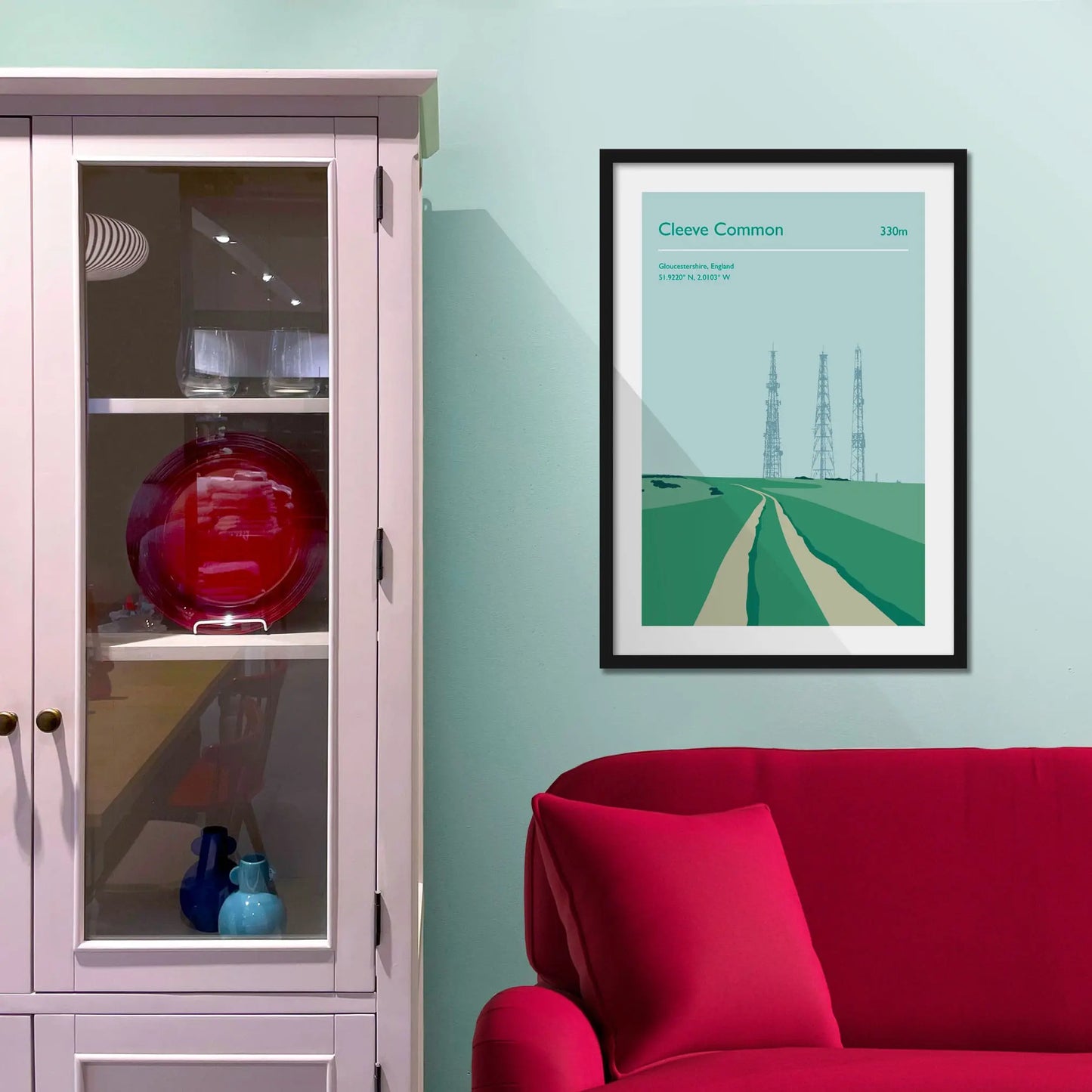 Framed picture on a baby blue wall beside pink shelving