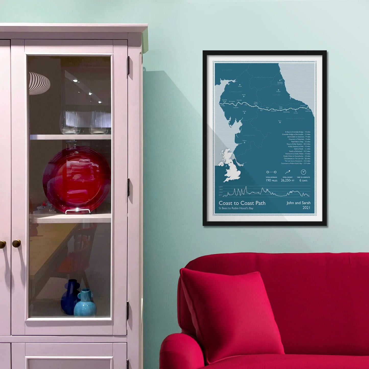 Framed picture on a baby blue wall beside pink shelving