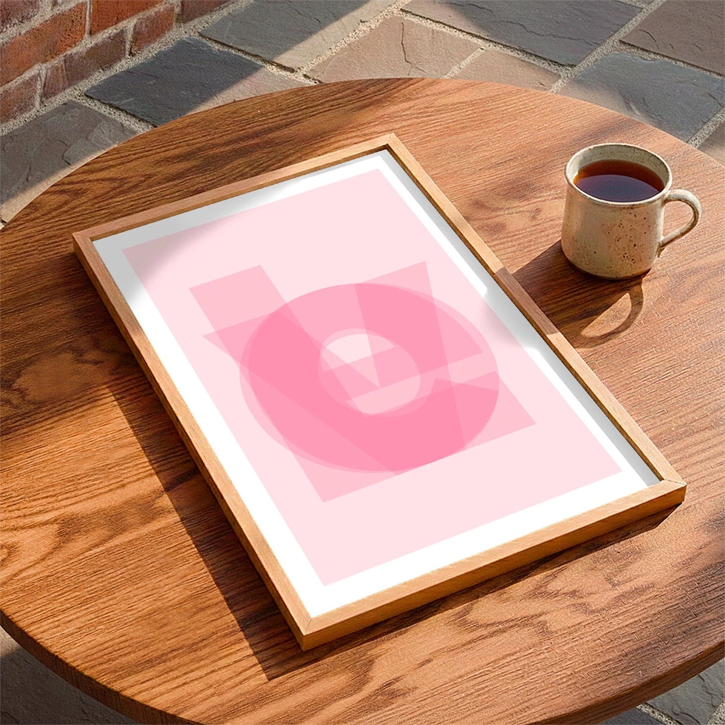 Framed print laying on a table beside a mug of tea