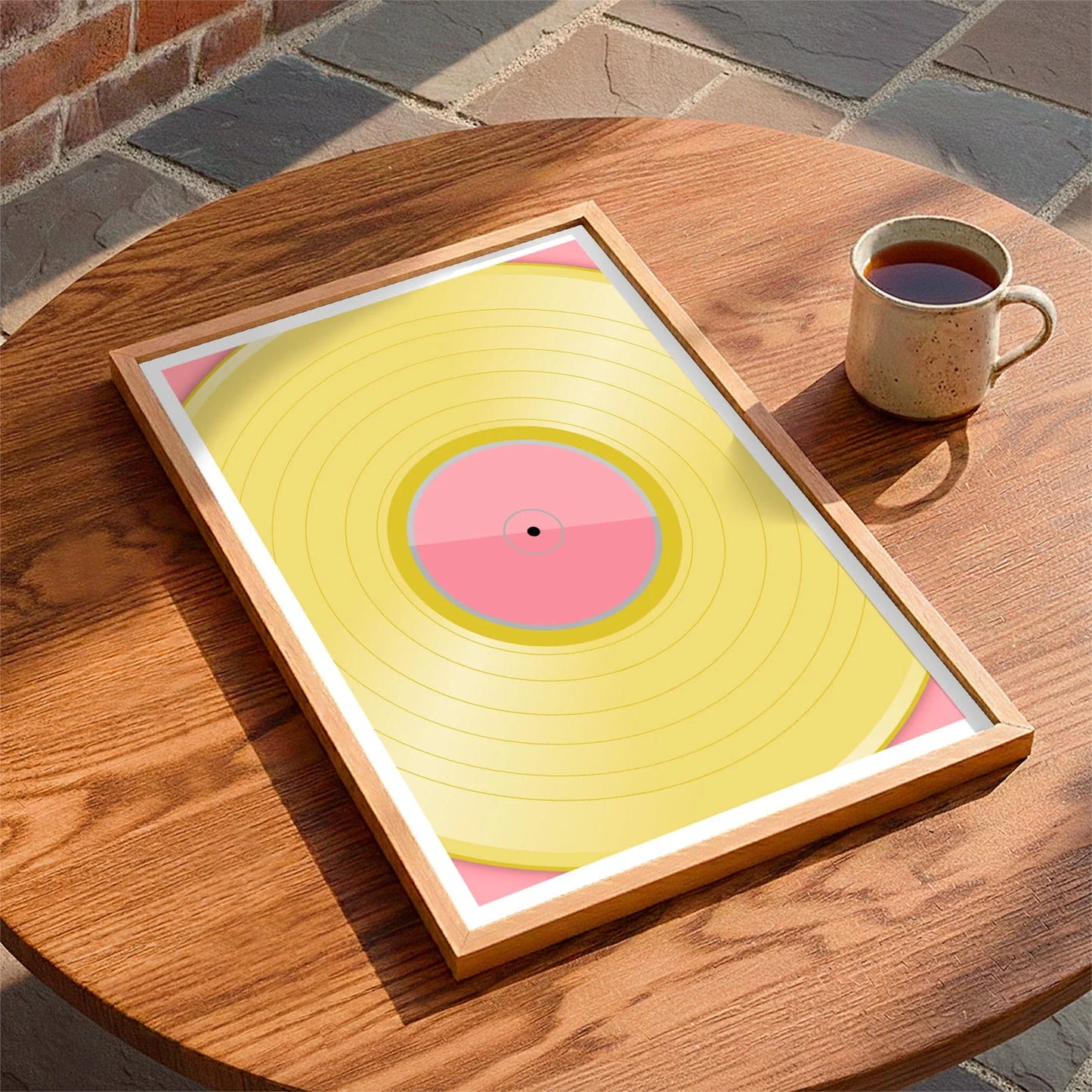 Framed print laying on a table beside a mug of tea