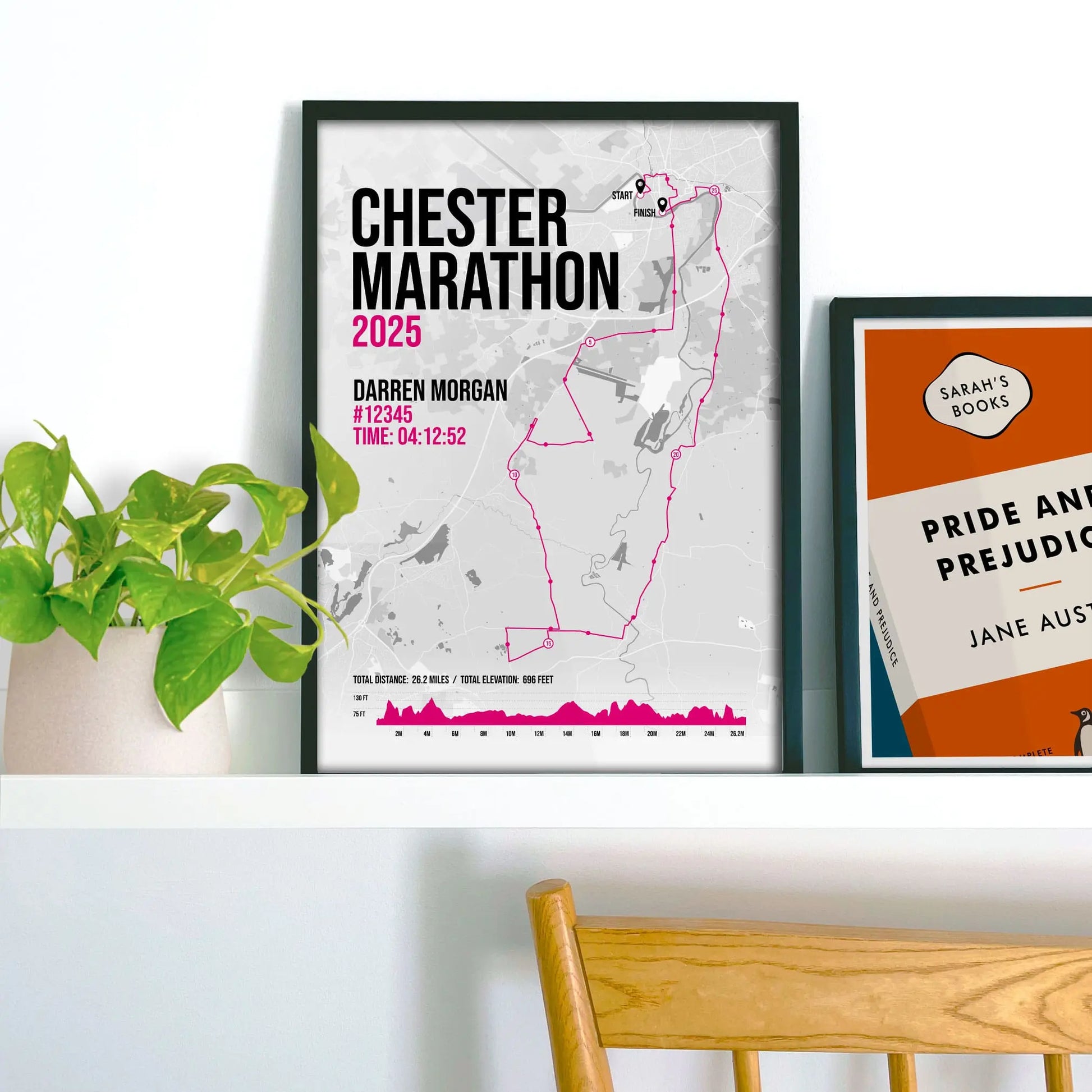 Framed print on shelf beside houseplant and another print