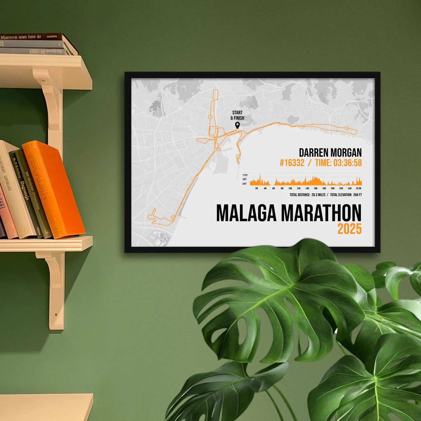 Framed art print on a green wall beside shelves.