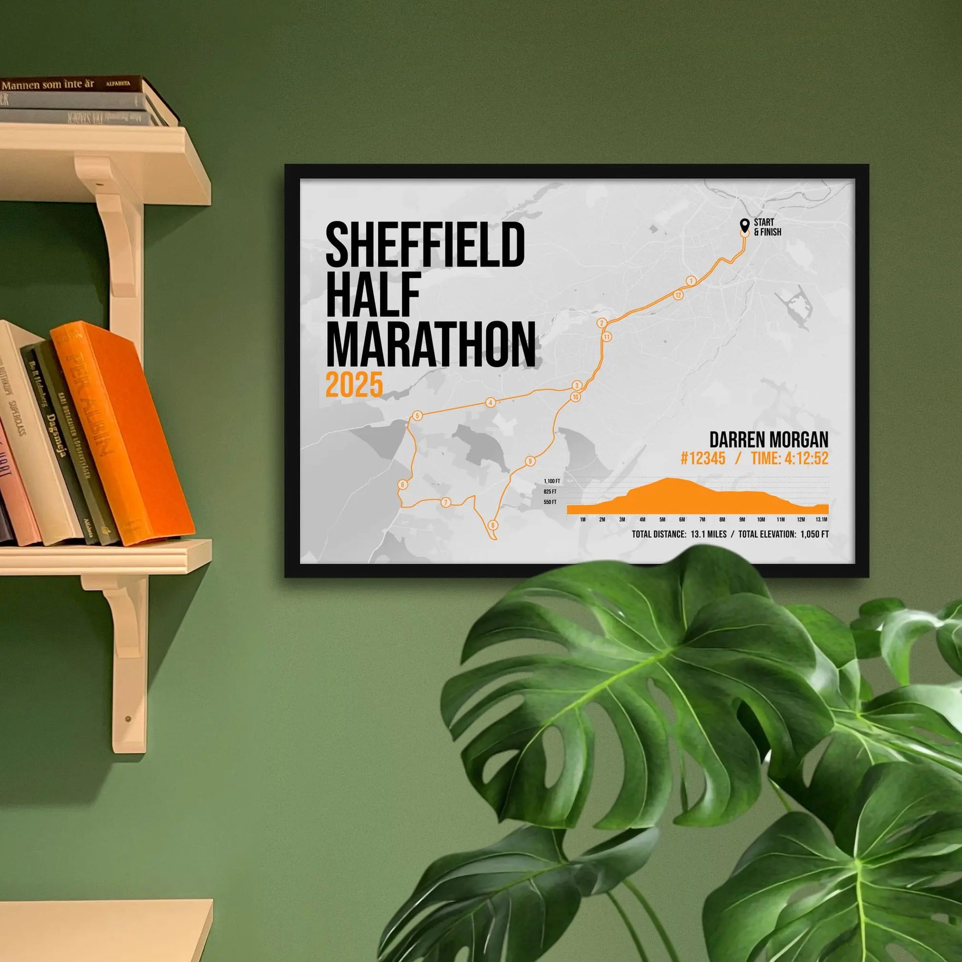 Print framed and in a black frame on a green wall beside some shelves