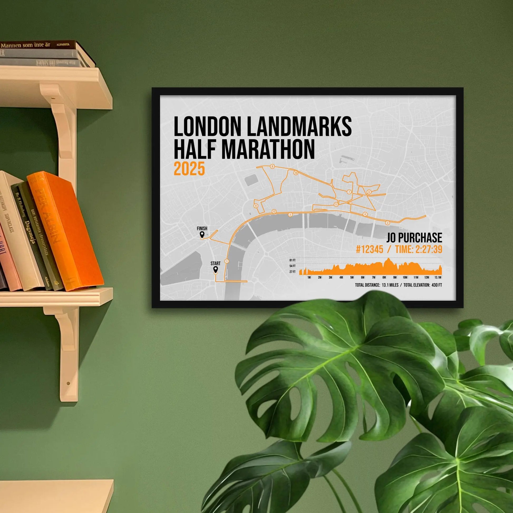 Print framed and in a black frame on a green wall beside some shelves