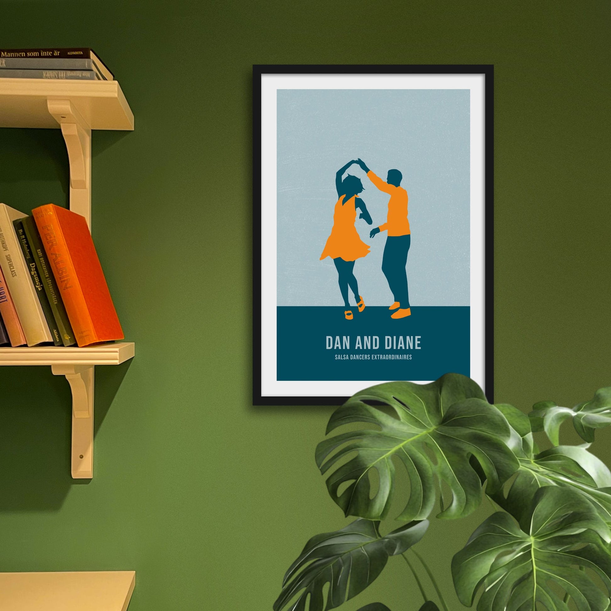 Framed picture on green wall beside shelves and behind a houseplant