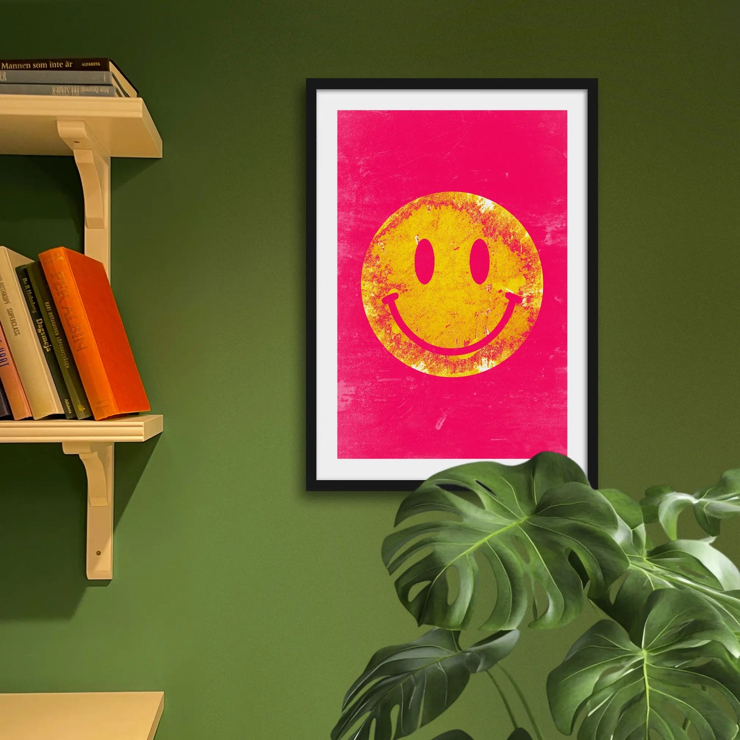 Framed print on green wall behind houseplant
