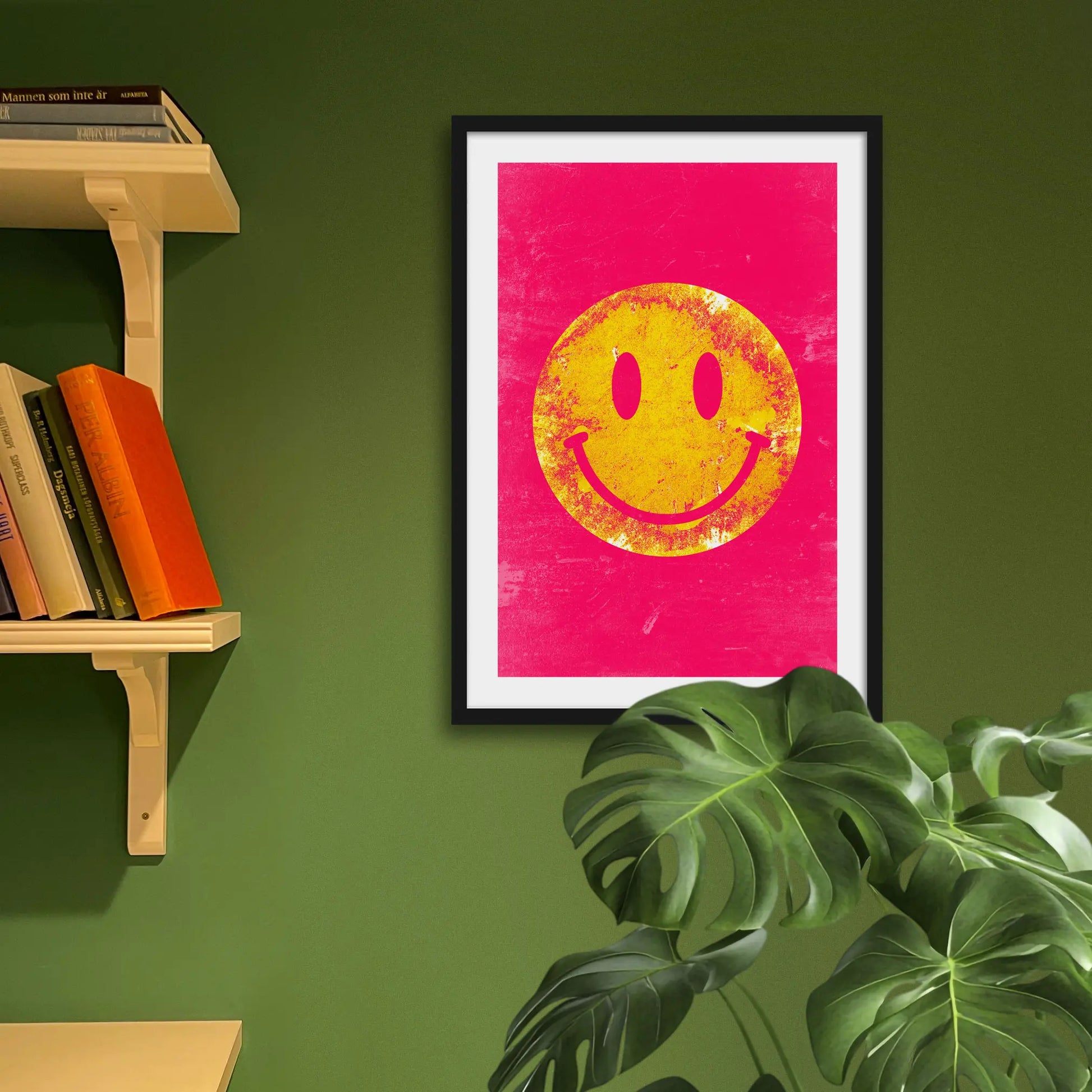 Framed print on green wall behind houseplant
