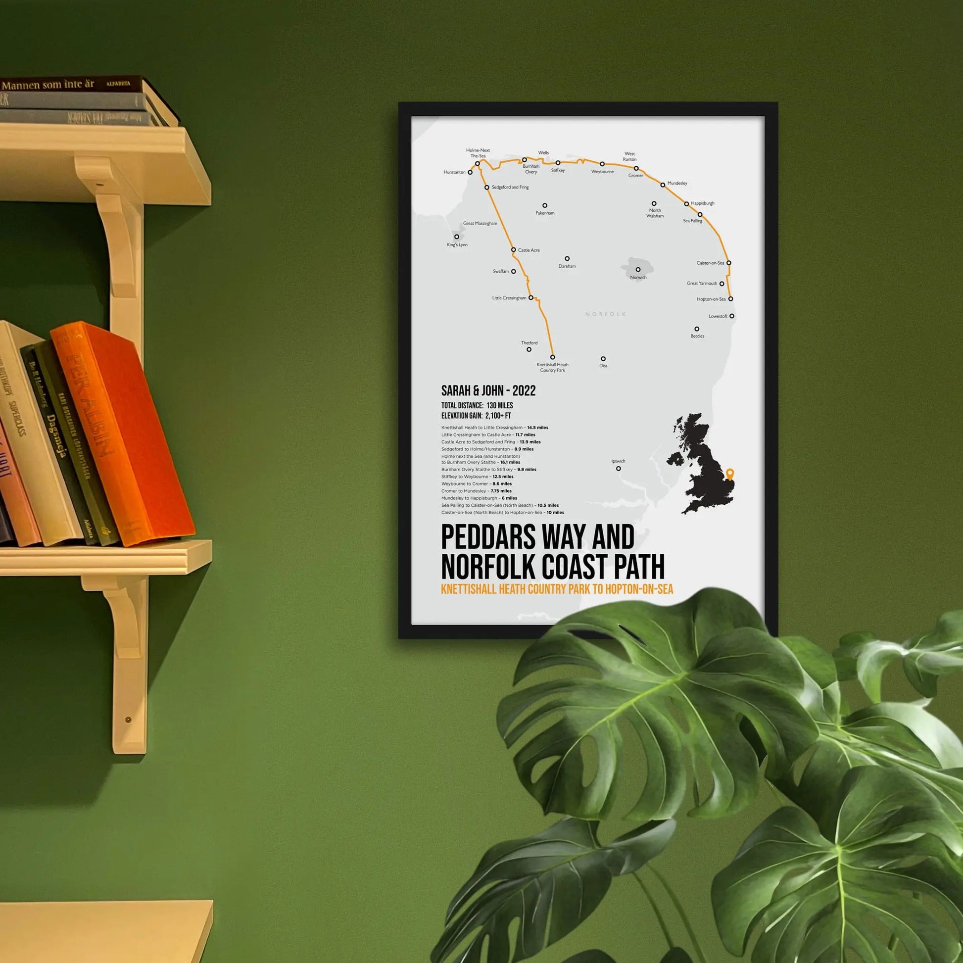 Framed art print on a green wall beside shelves.