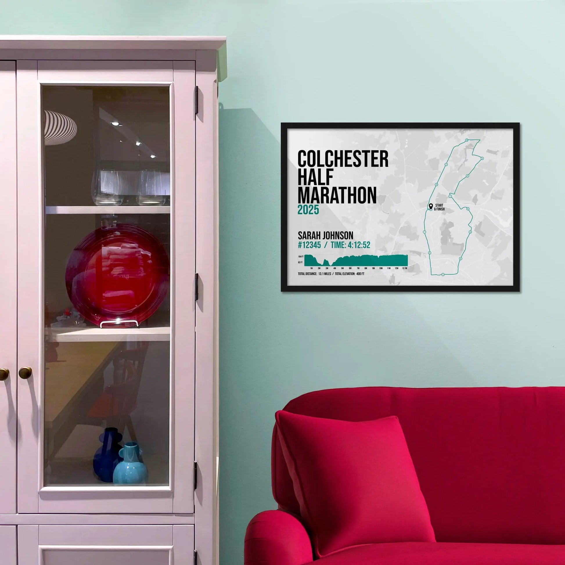 Framed picture on a baby blue wall beside pink shelving