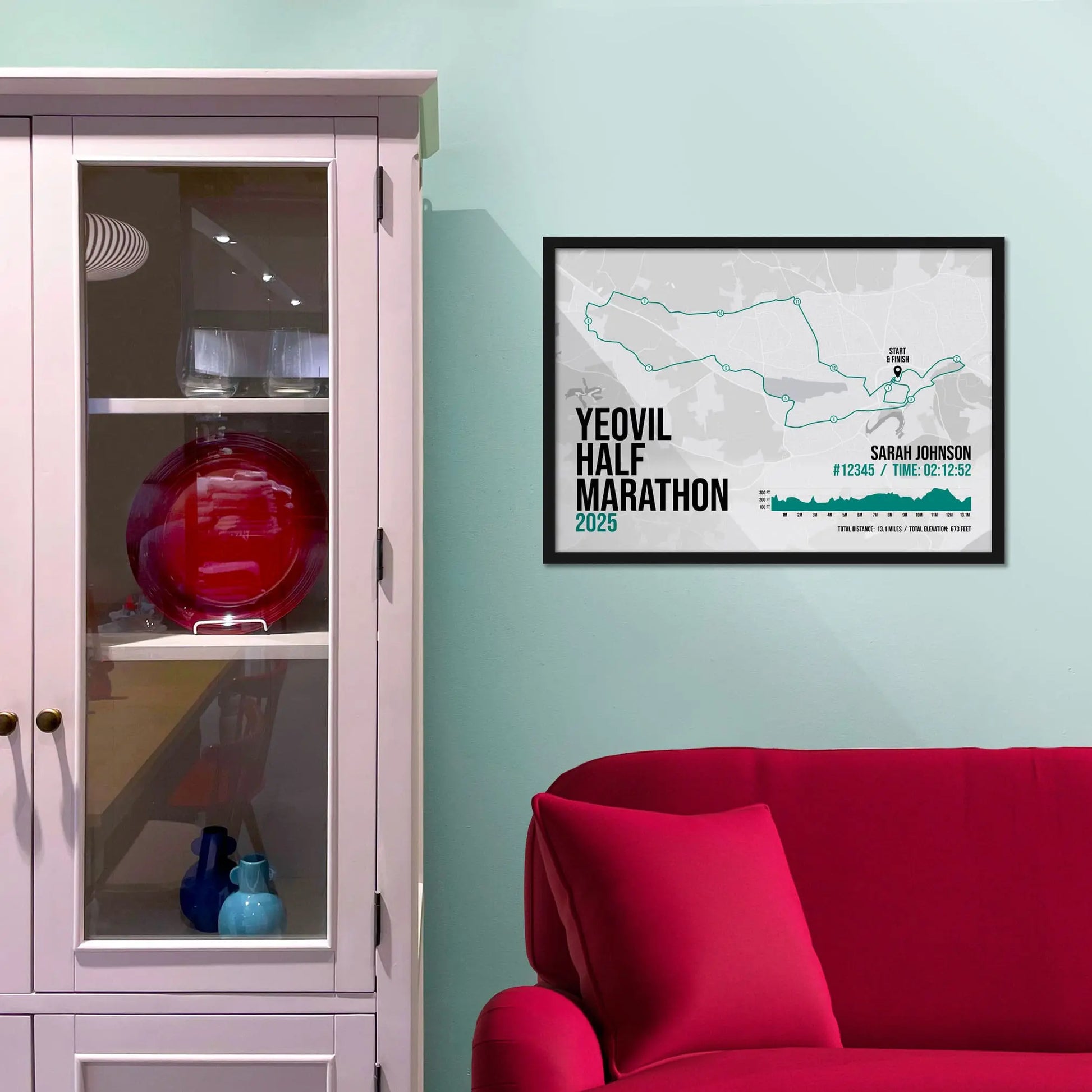 Framed picture on a baby blue wall beside pink shelving
