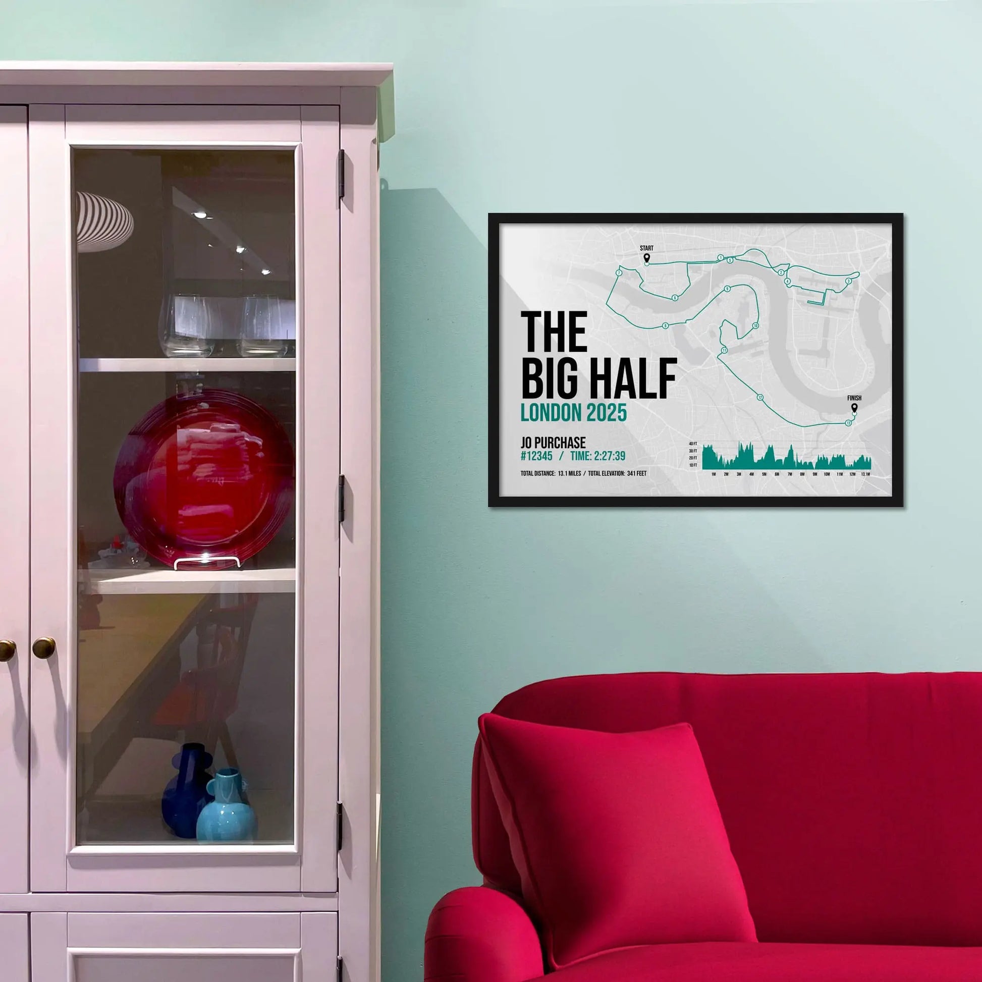 Framed picture on a baby blue wall beside pink shelving