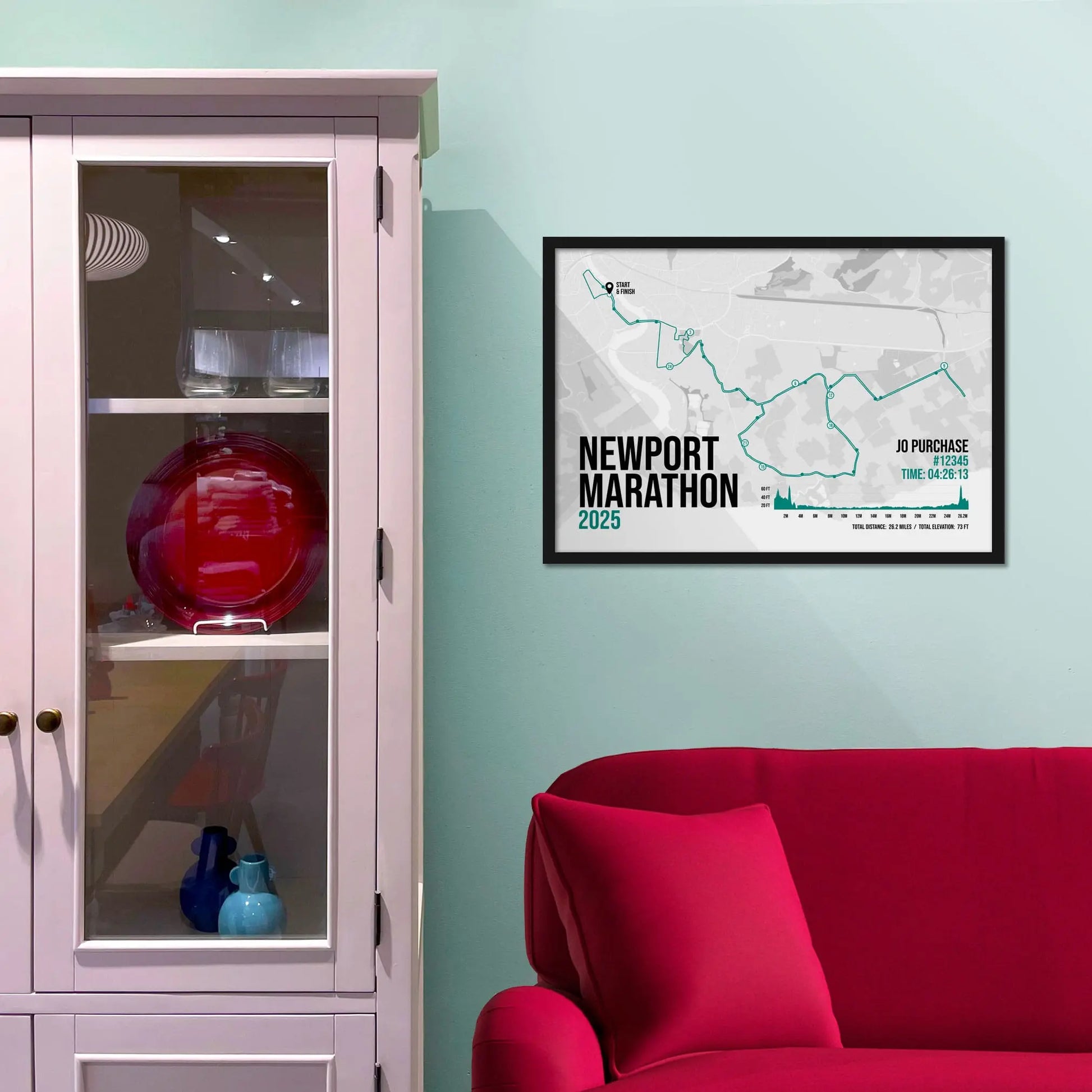 Framed picture on a baby blue wall beside pink shelving