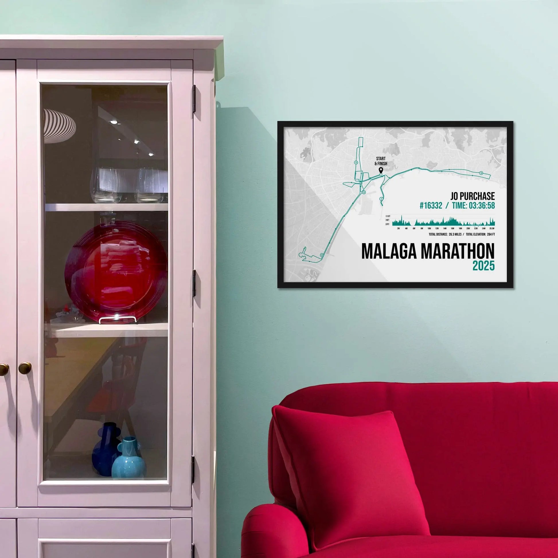 Framed picture on a baby blue wall beside pink shelving