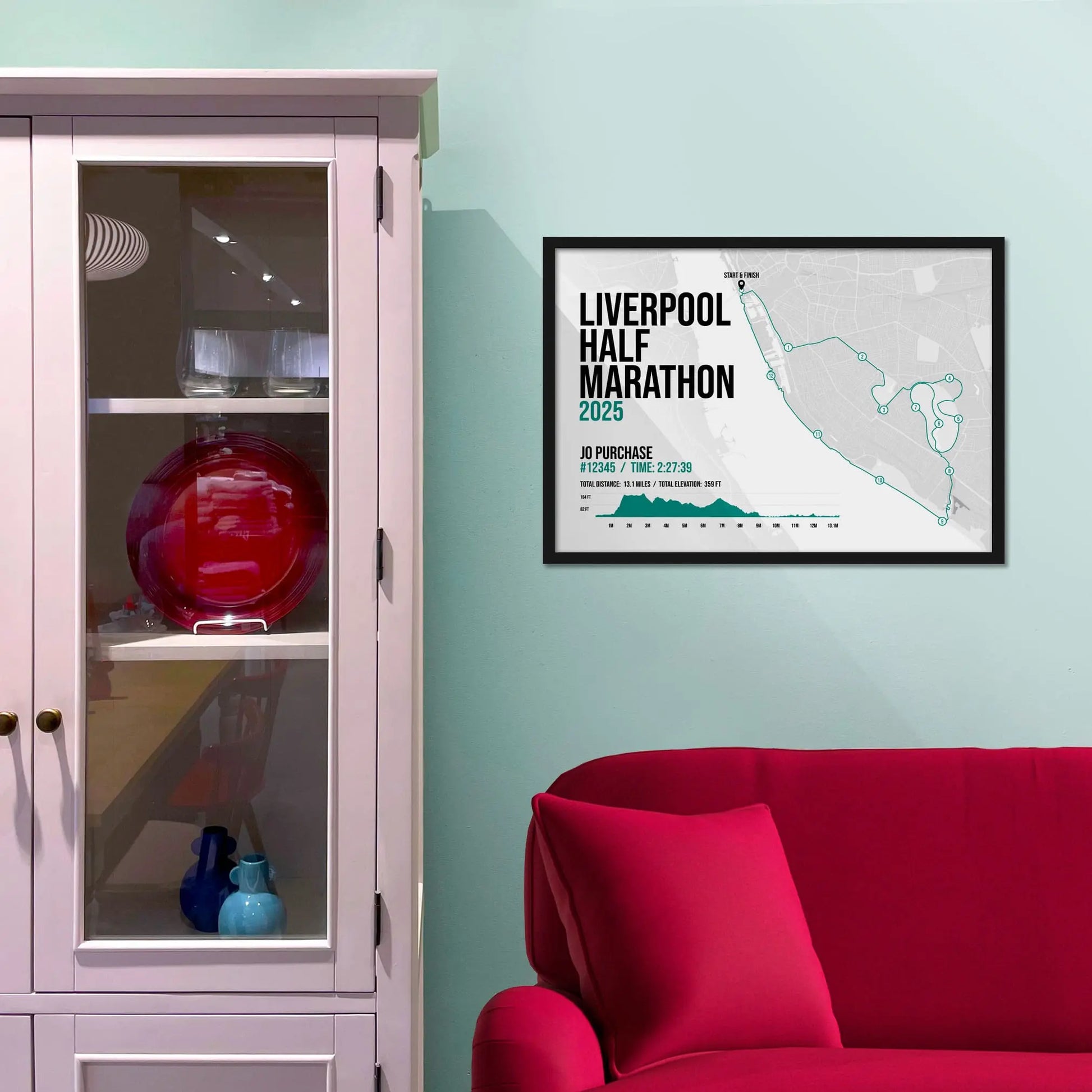 Framed picture on a baby blue wall beside pink shelving